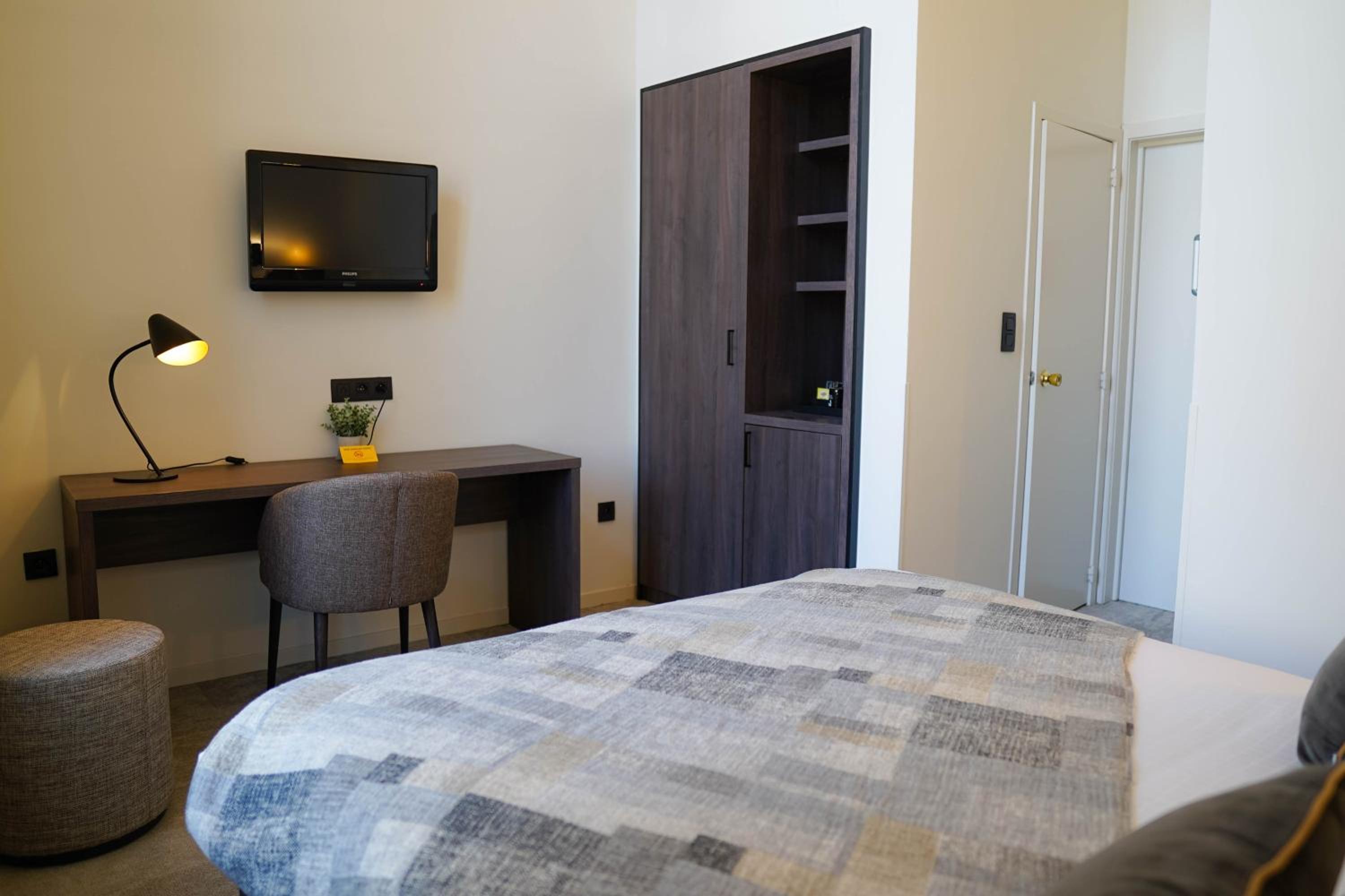 bedroom with a bed, desk, chair and television