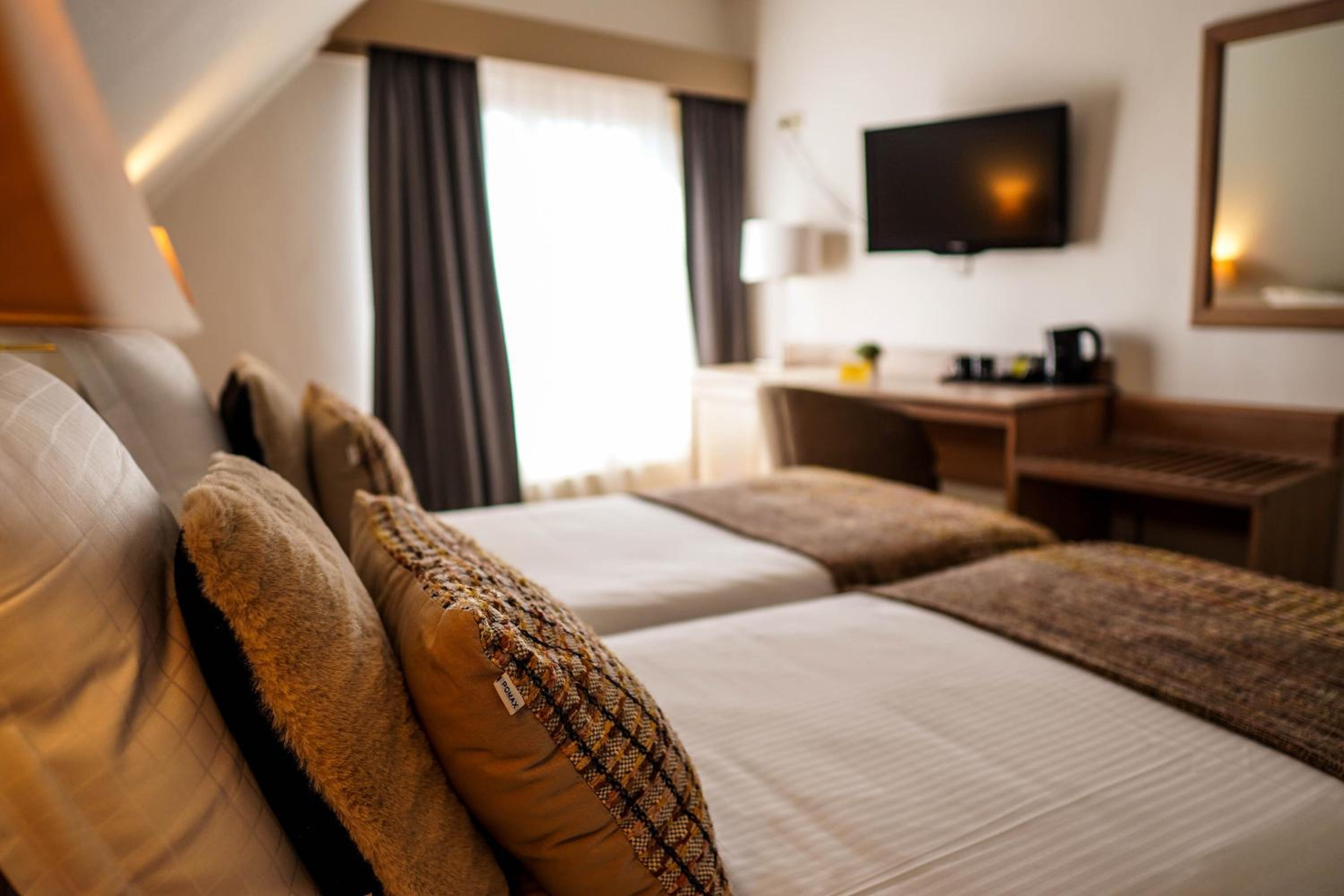hotel room with two beds and a flat screen tv