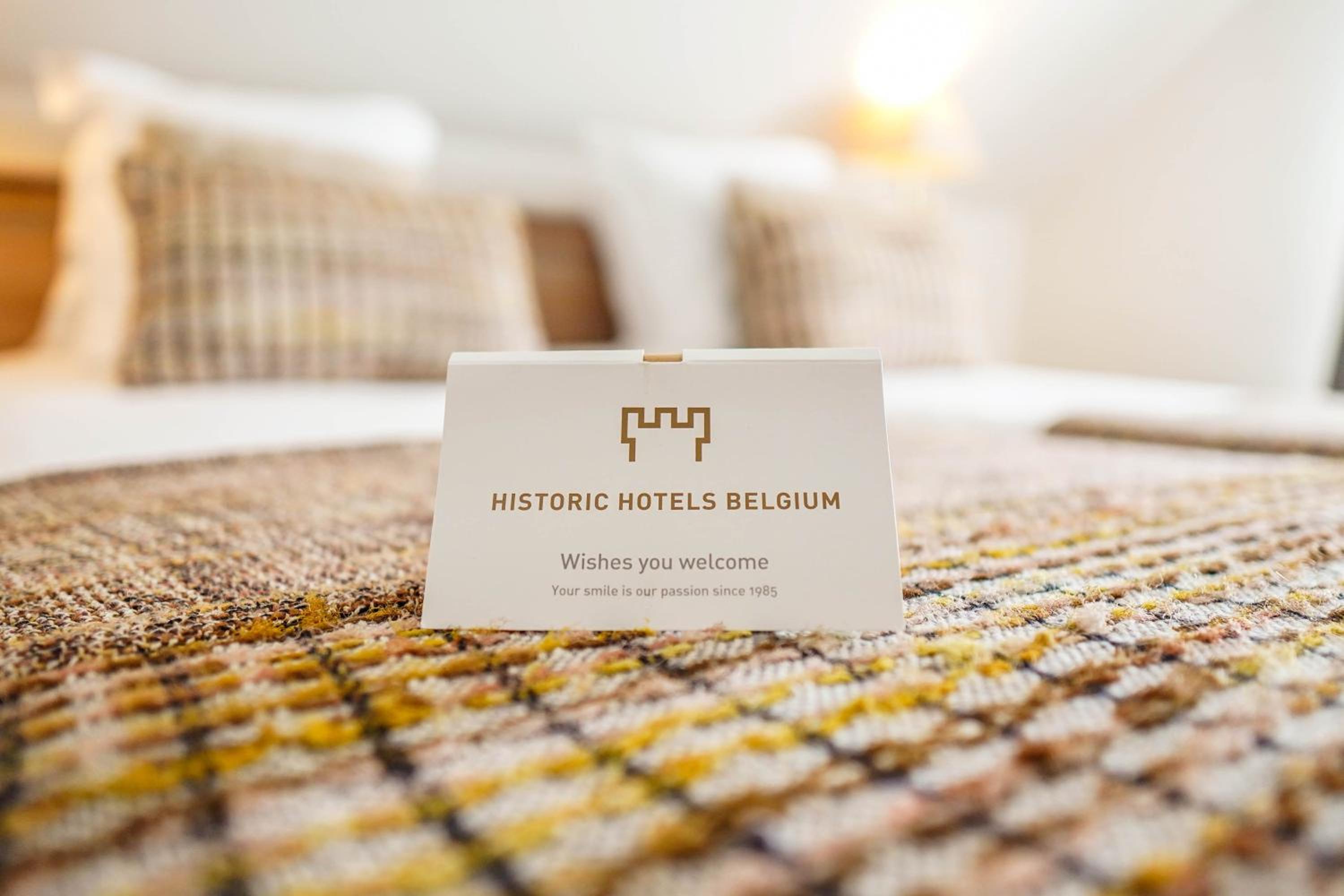 hotel bed with a business card on top of it