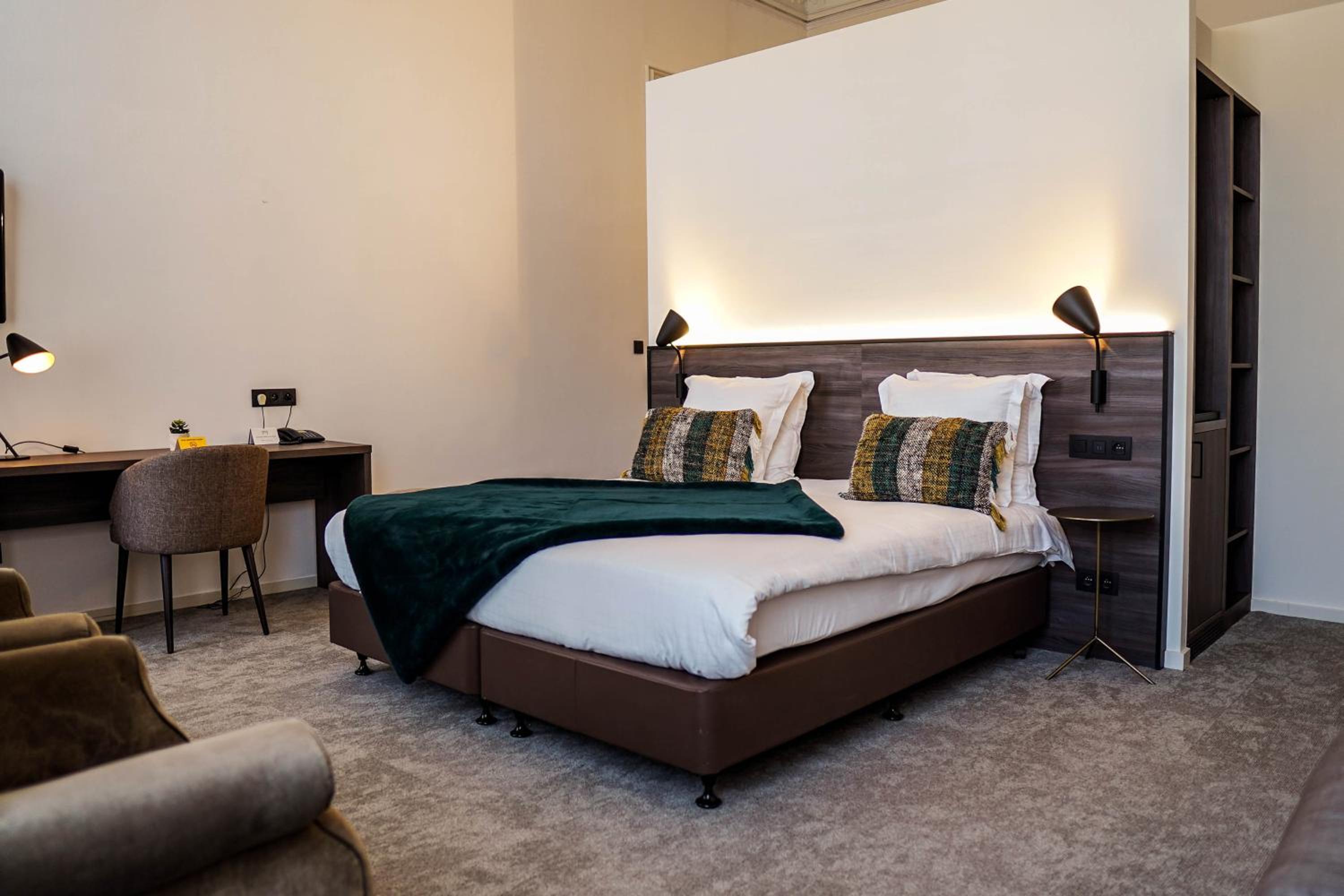 hotel room with a bed, desk, and chair