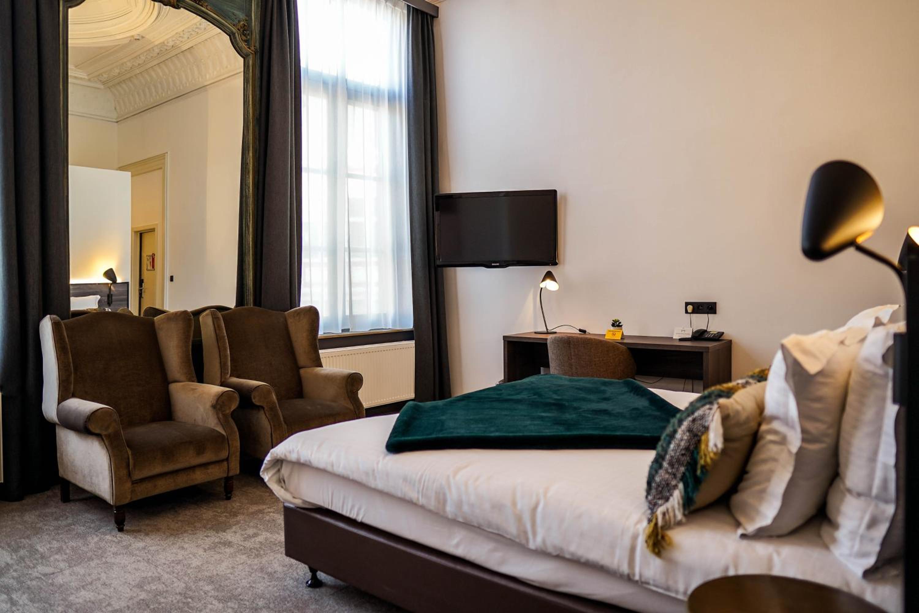 hotel room with a bed, chair, and television