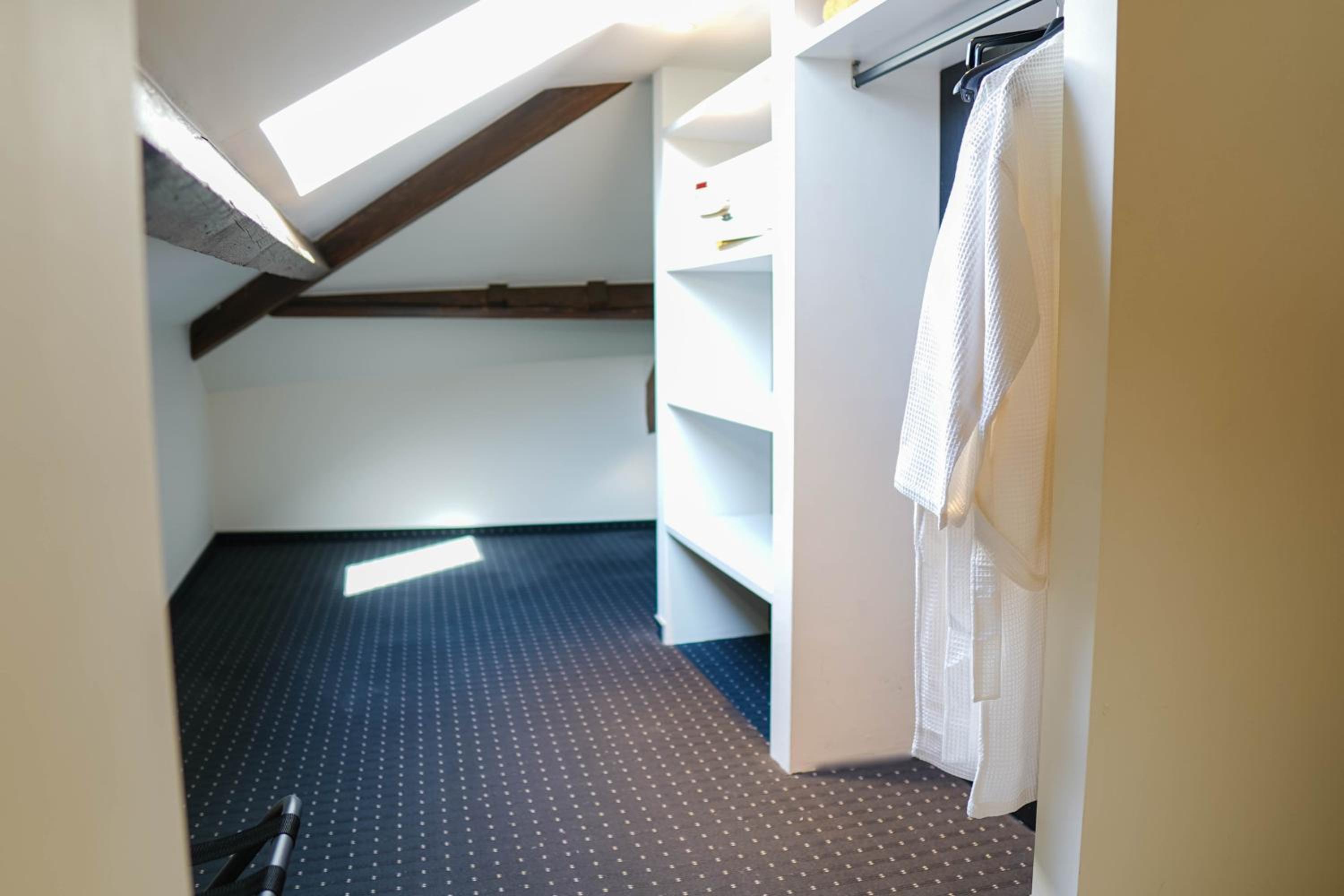 walk - in closet with a robe hanging on it