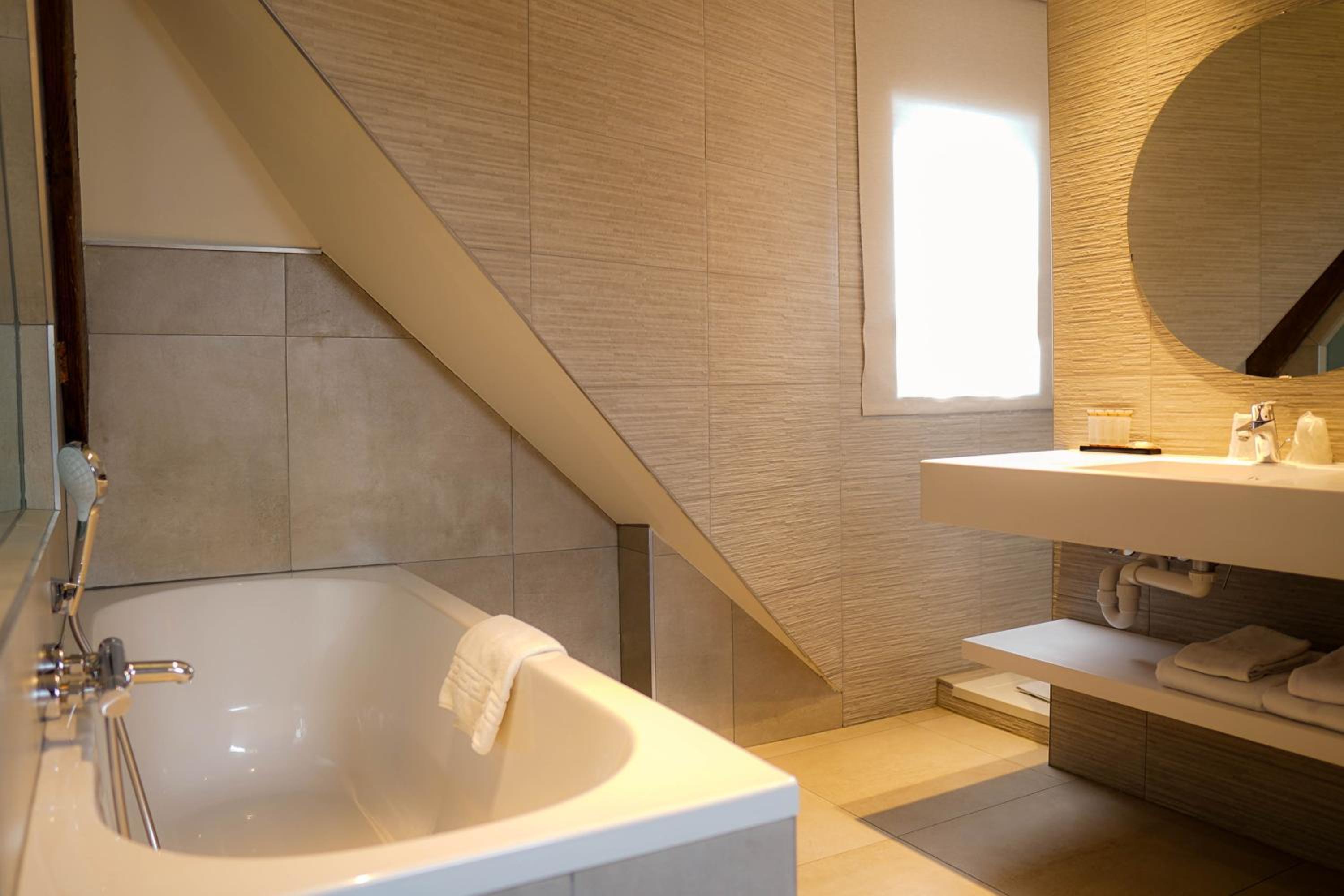 bathroom with a bathtub, sink, and mirror