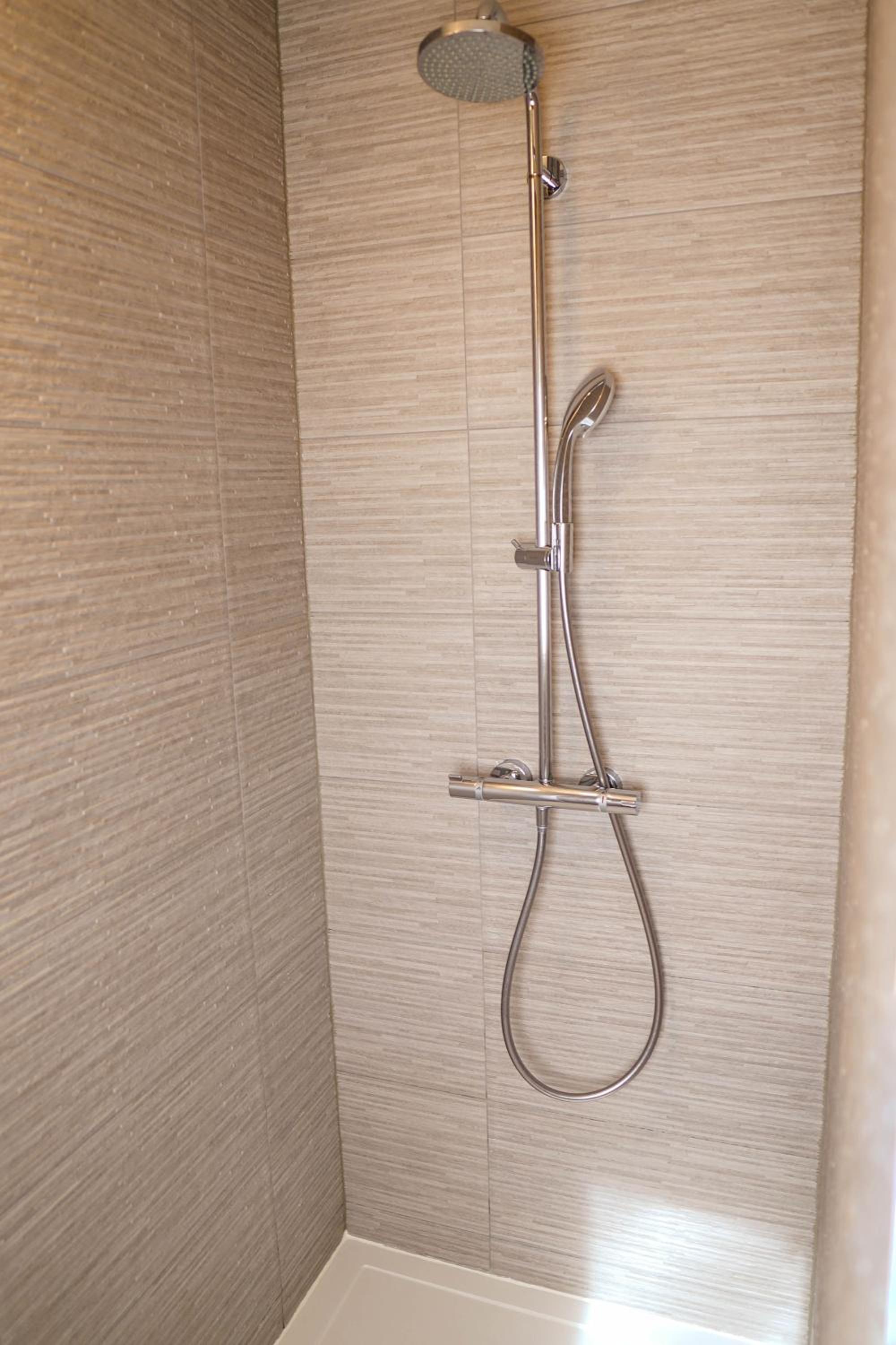 bathtub with a shower head and hand held shower