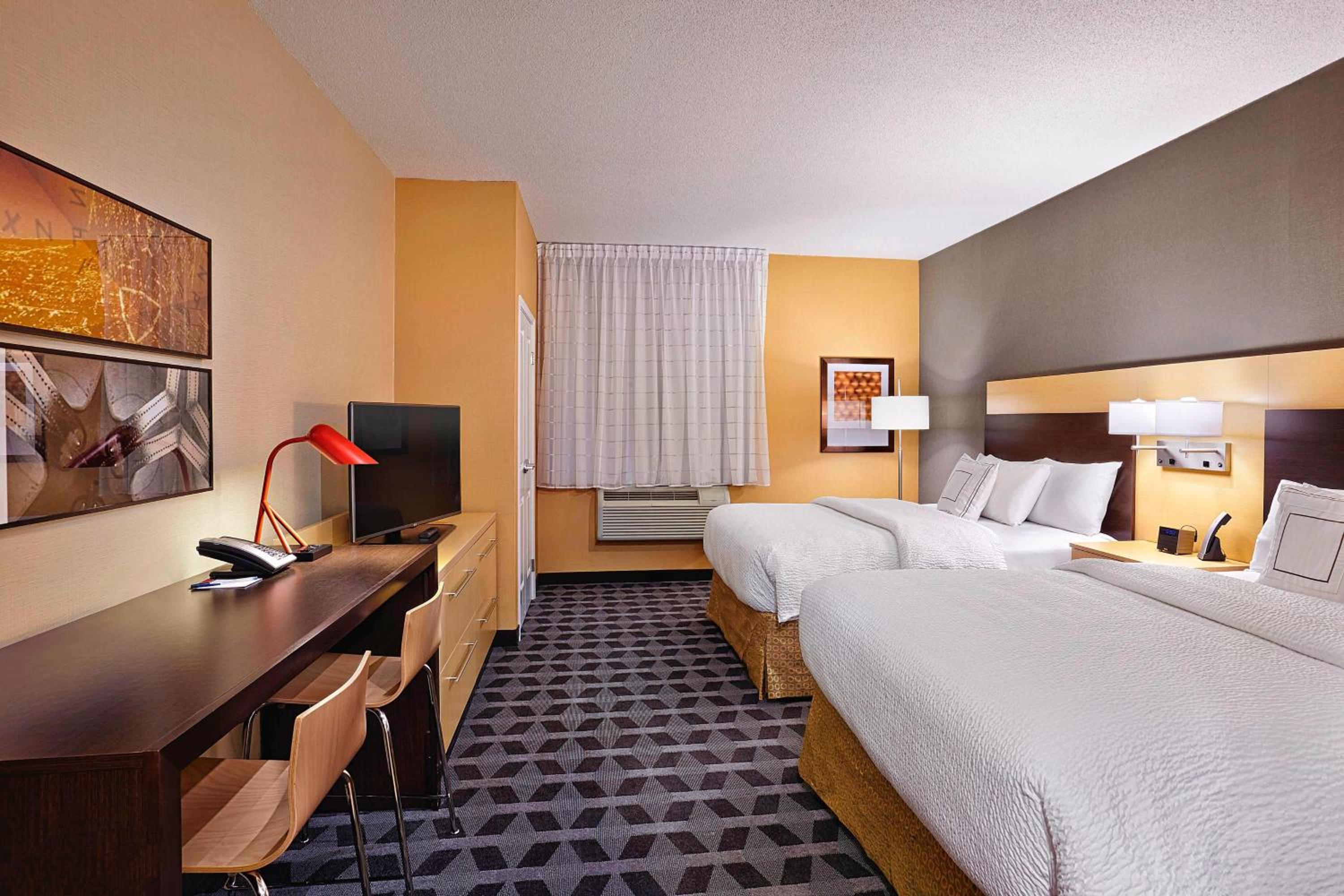 hotel room with two beds and a flat screen tv