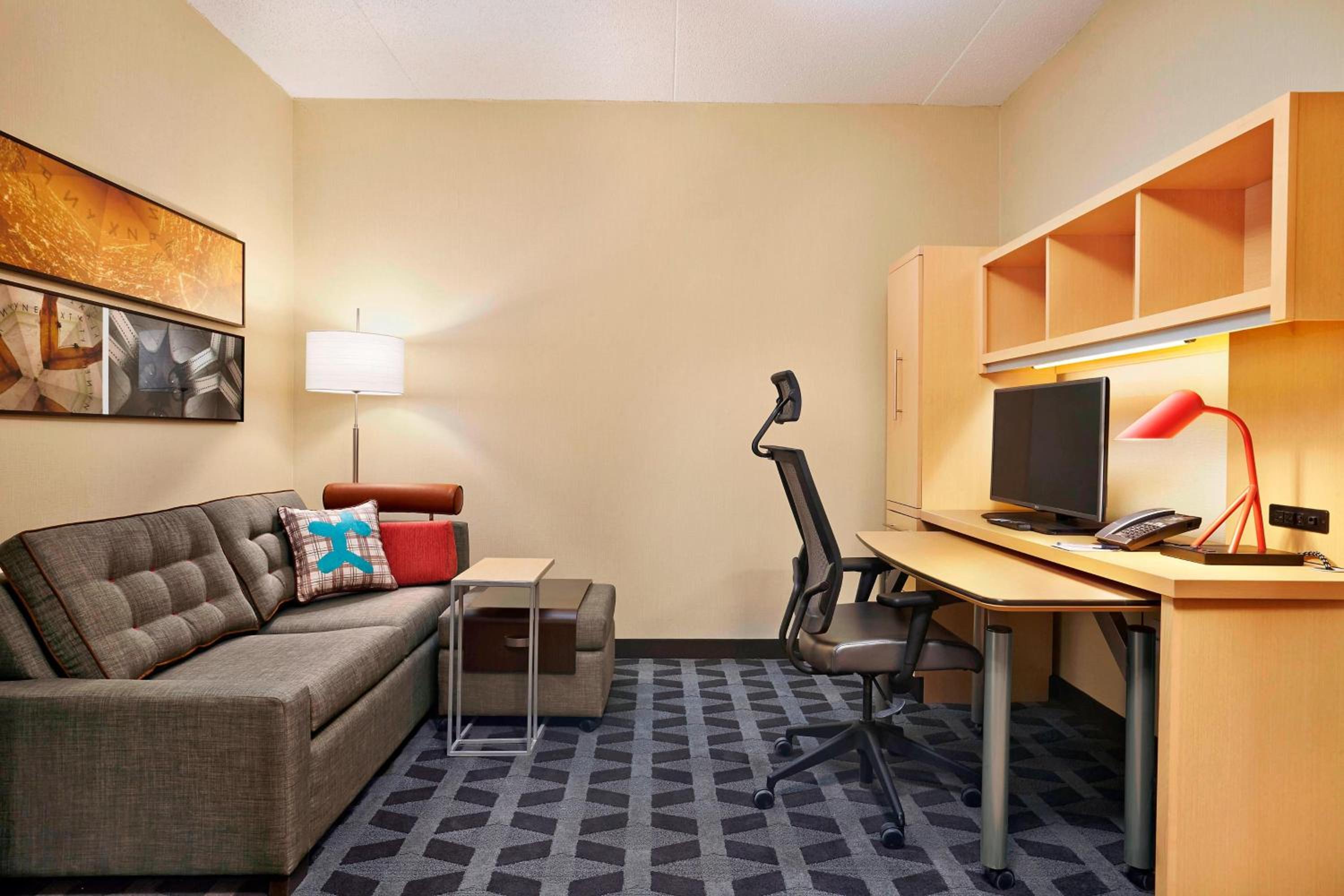 living room with a couch, desk, and television