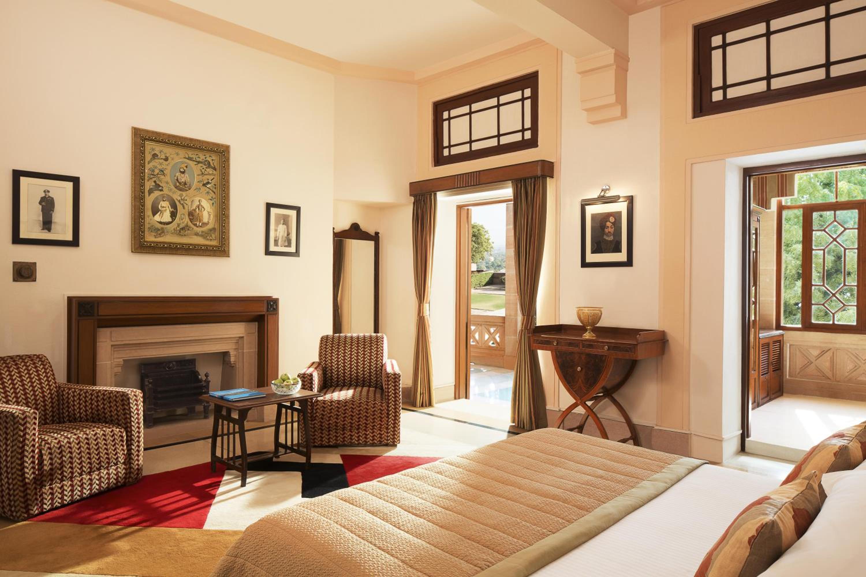 room with a bed, chairs, and a fireplace