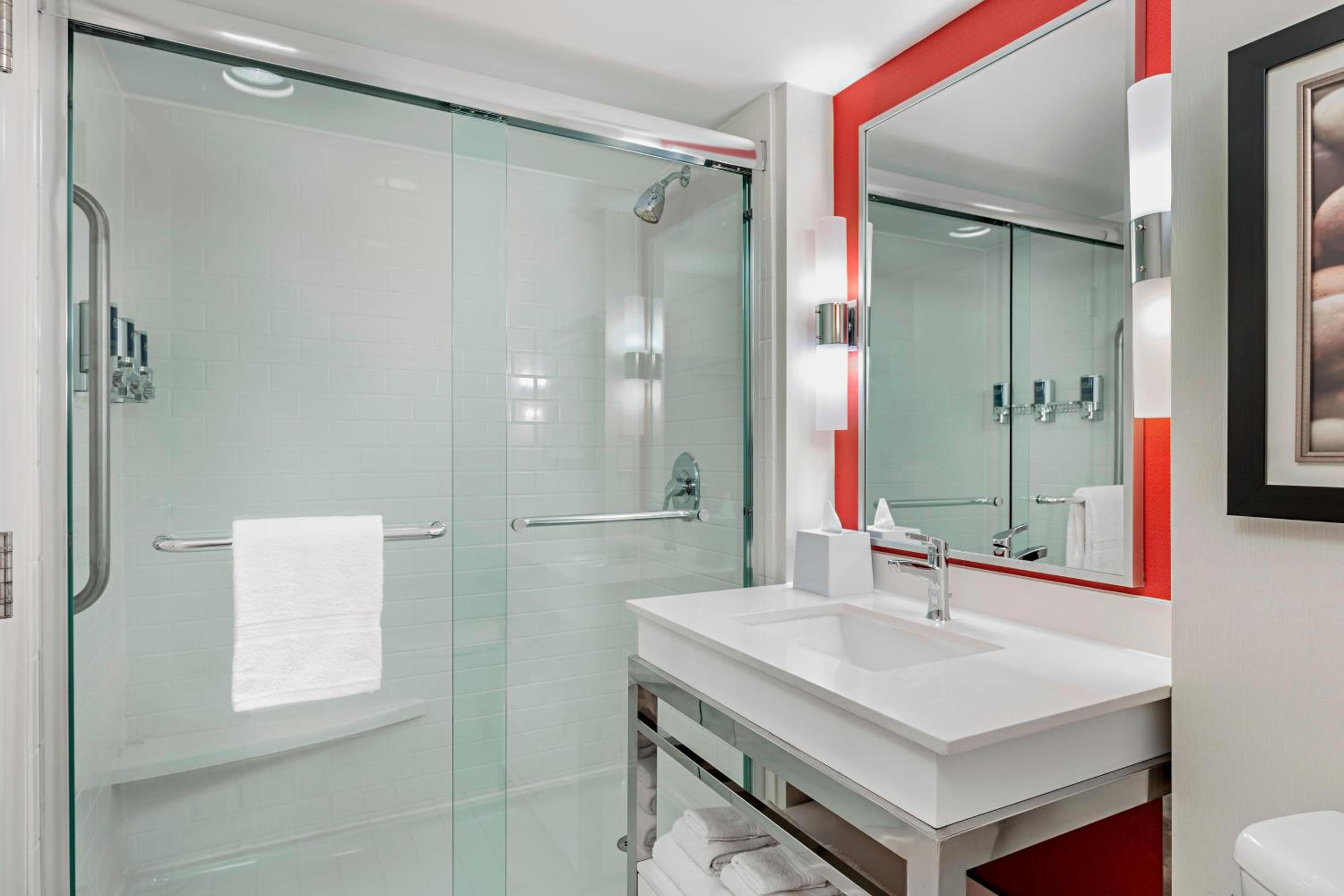 bathroom with a shower, sink, toilet and mirror