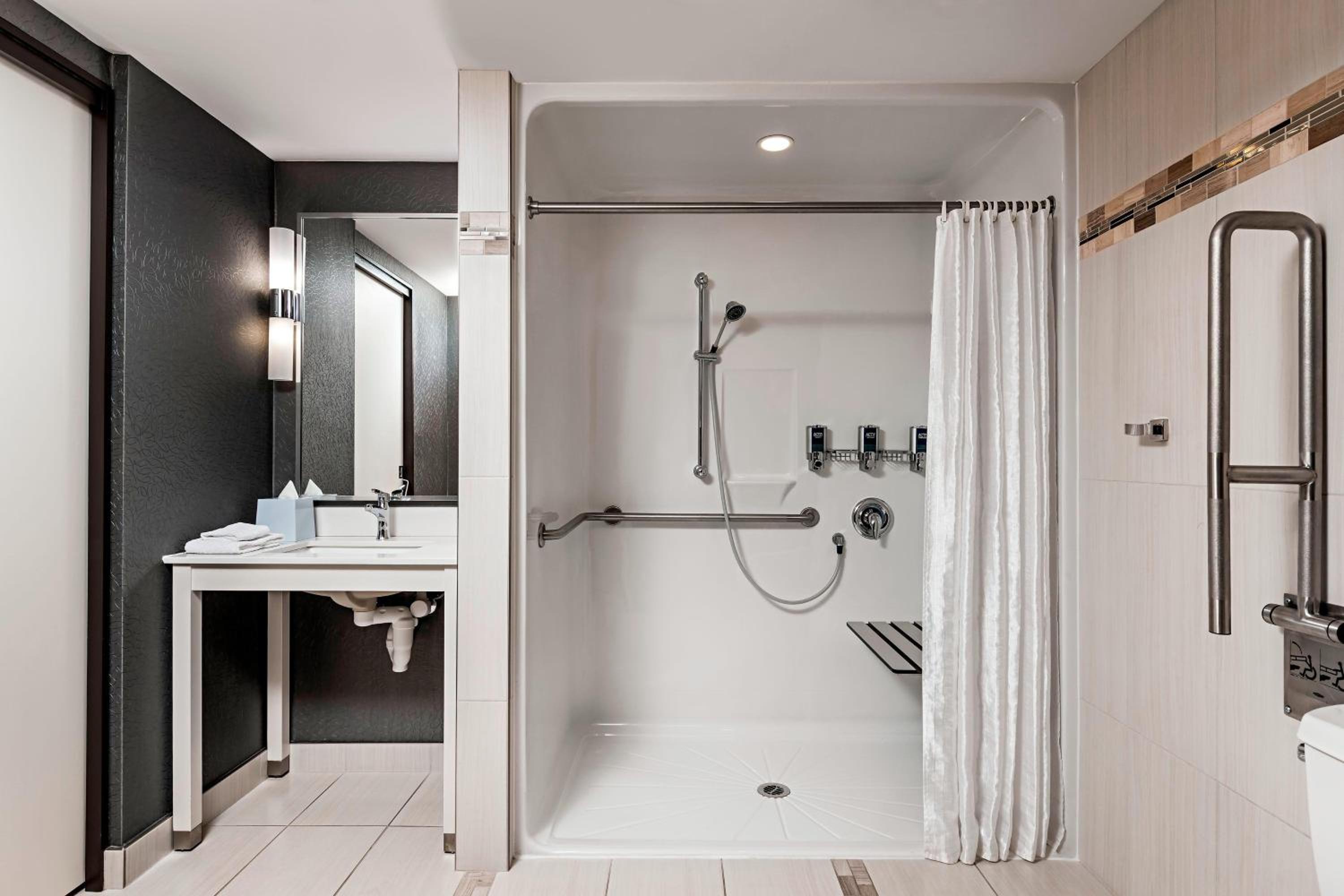 bathroom with a shower, toilet, sink and mirror