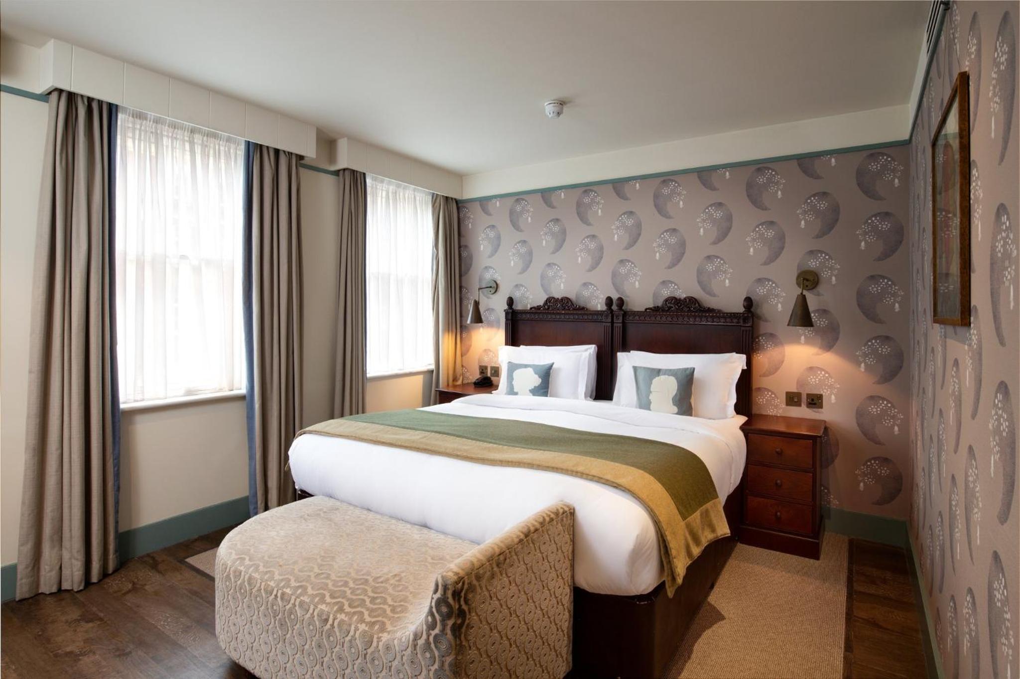 hotel room with a king size bed and an ottoman