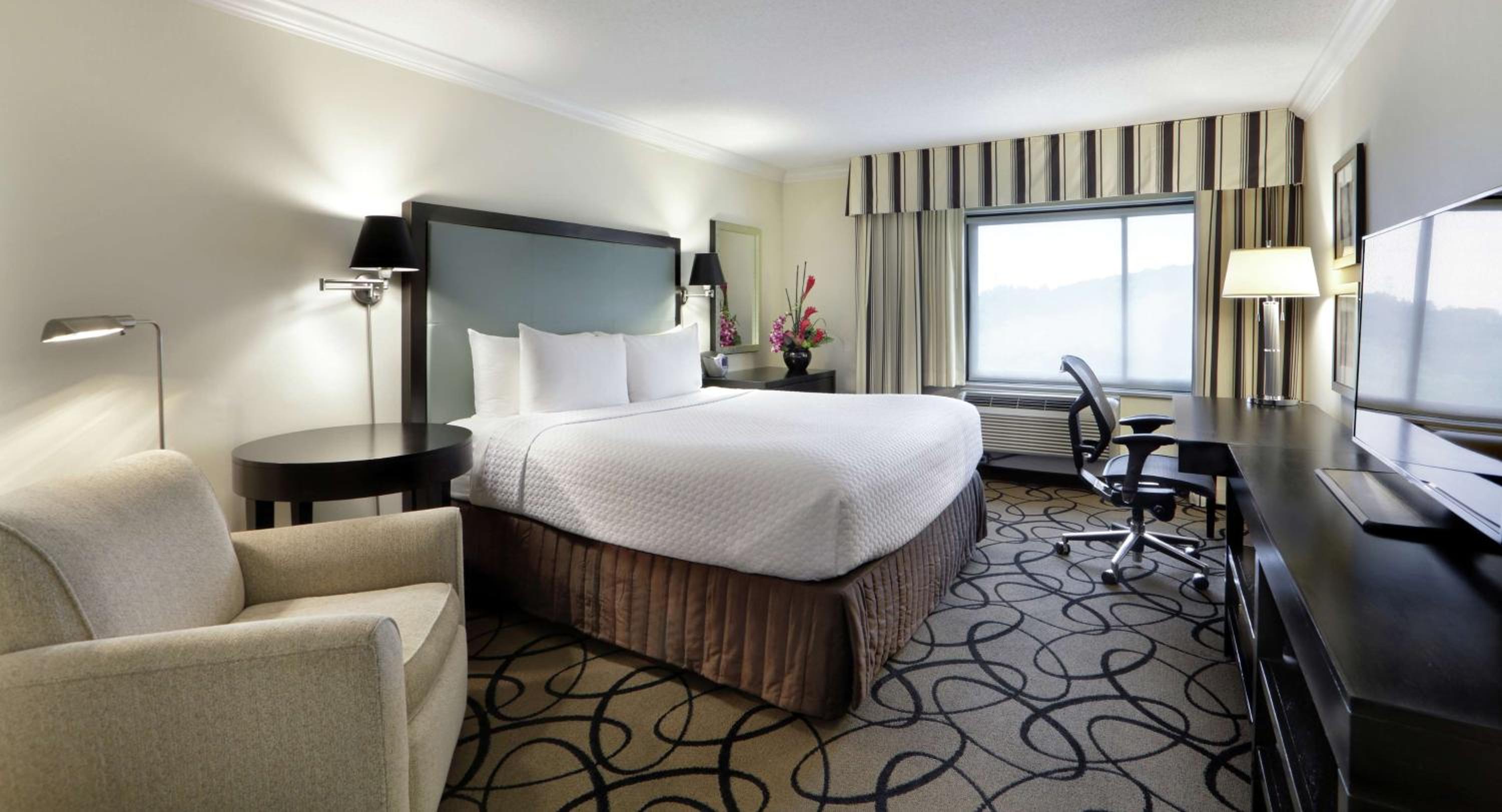 Relax in this cozy, stylish hotel room retreat.