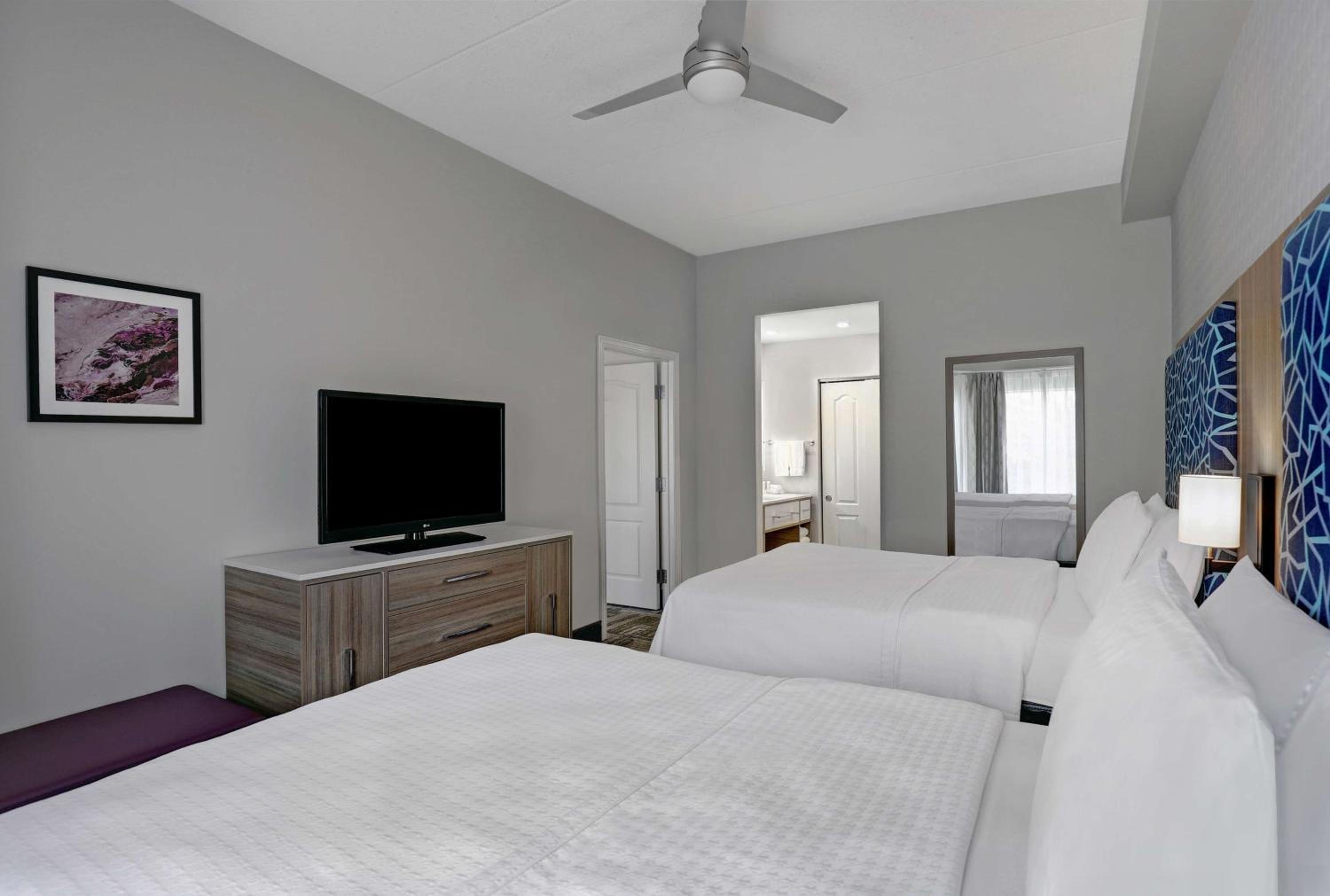 hotel room with two beds and a flat screen tv