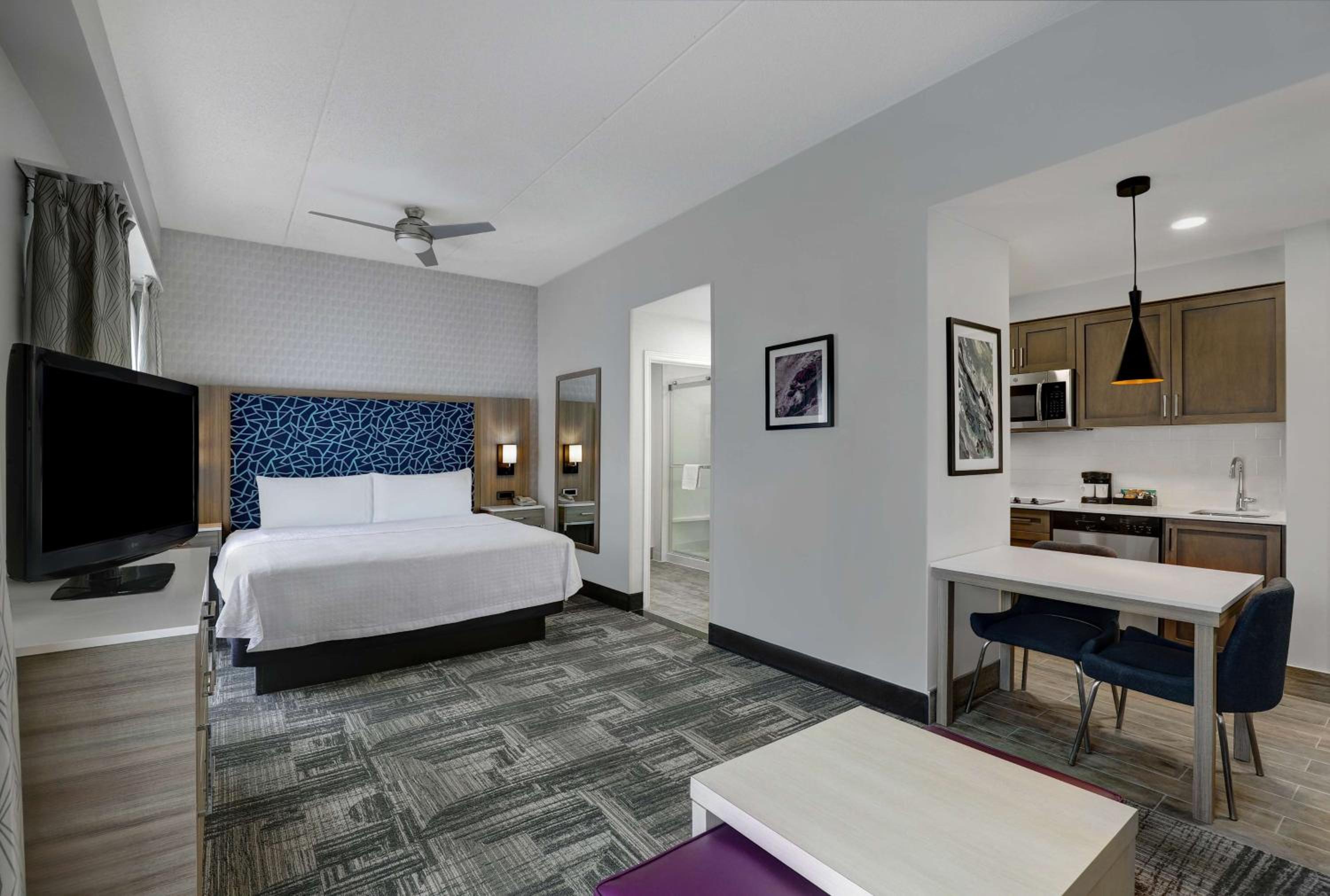 hotel room with a bed, desk, and television