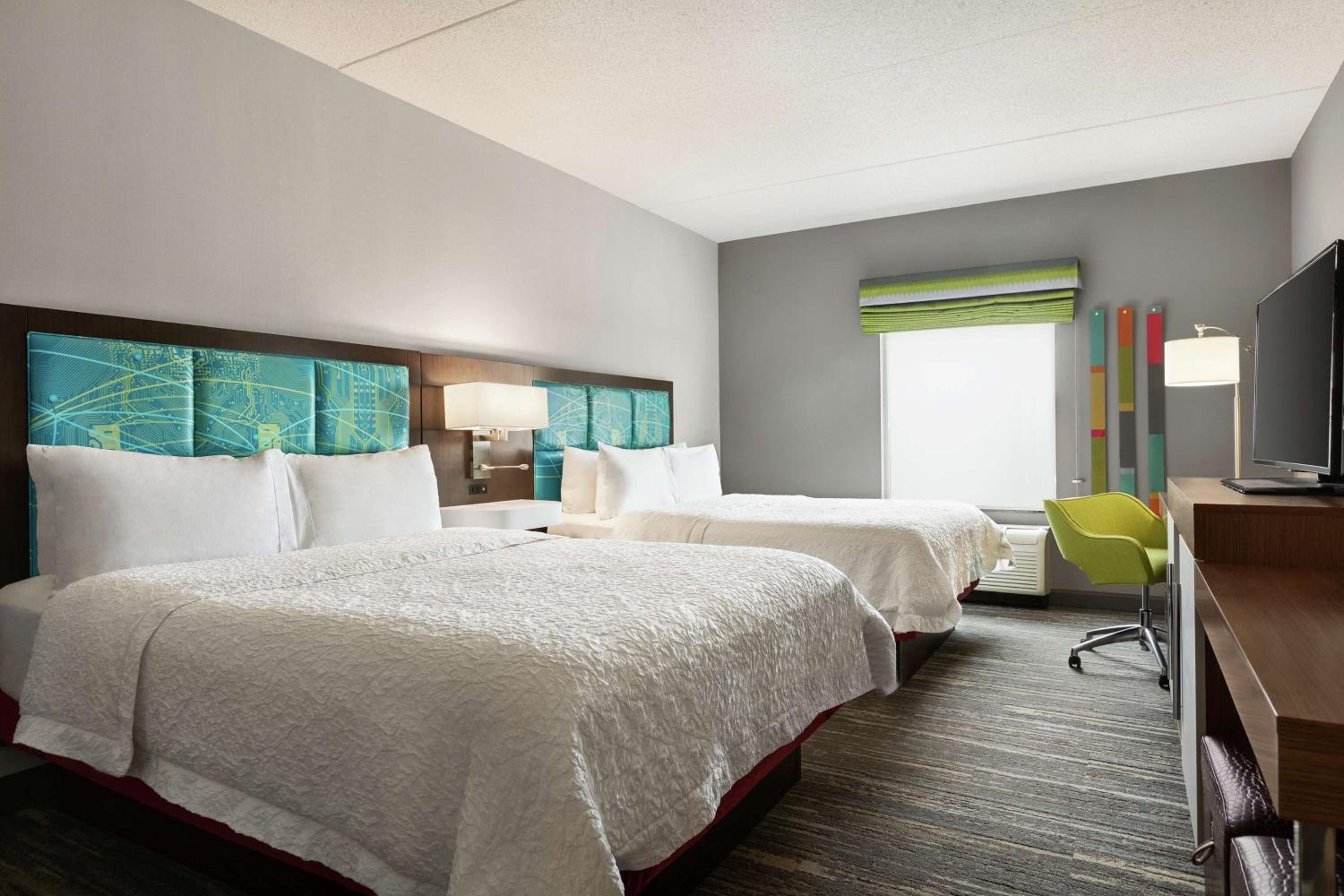 hotel room with two beds and a flat screen tv
