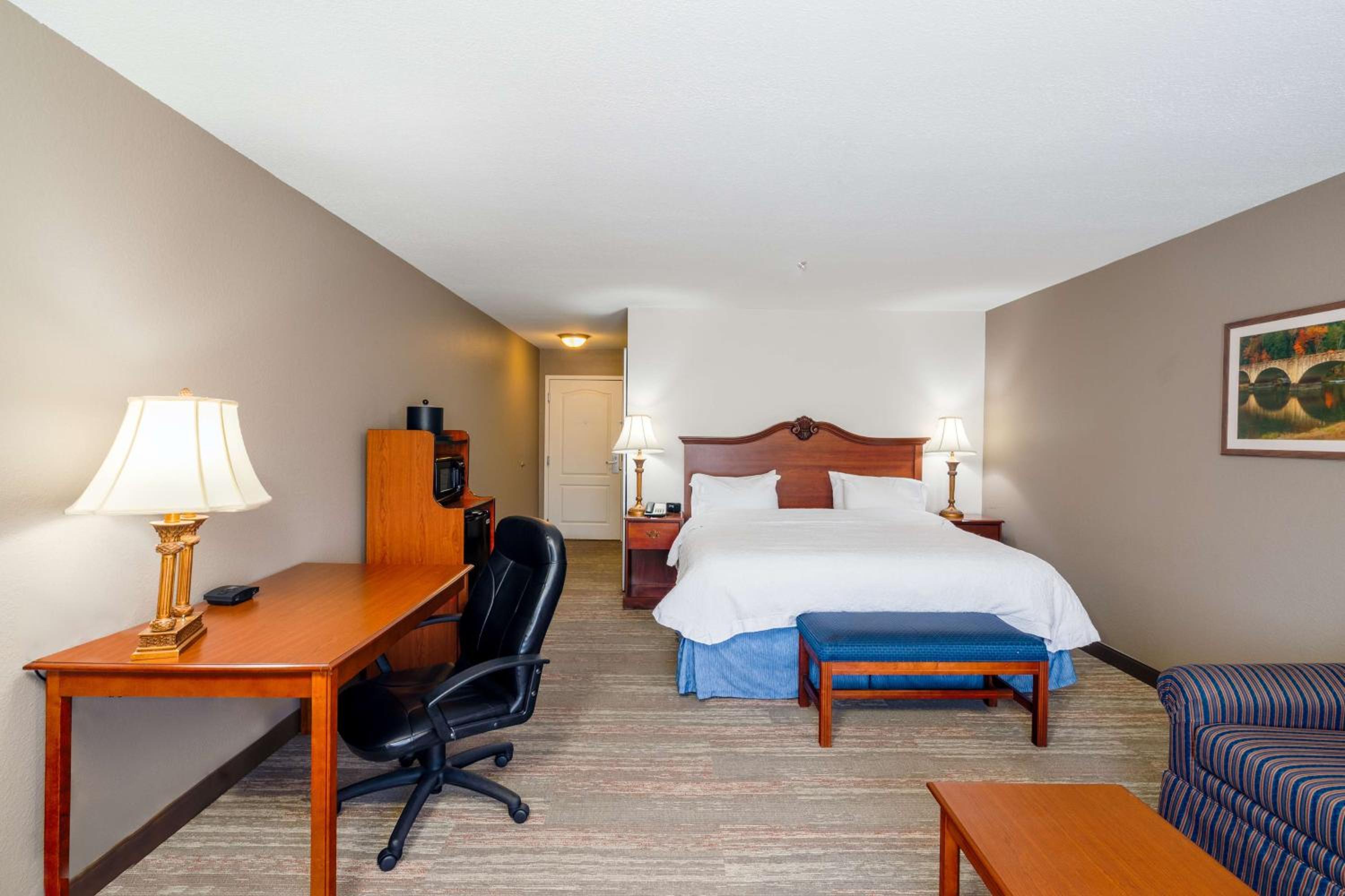 hotel room with a bed, desk, and chair