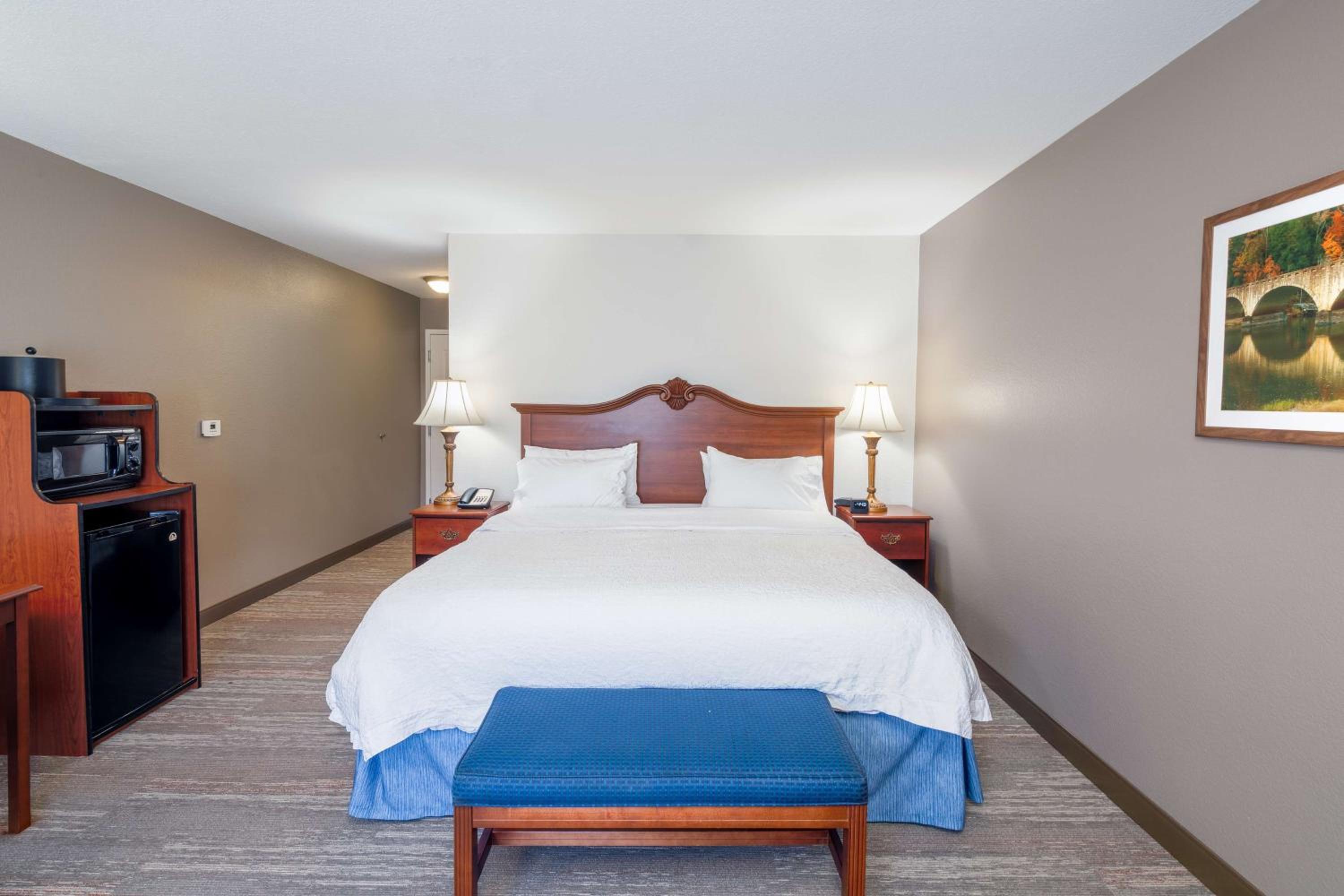 hotel room with a bed, desk, and television
