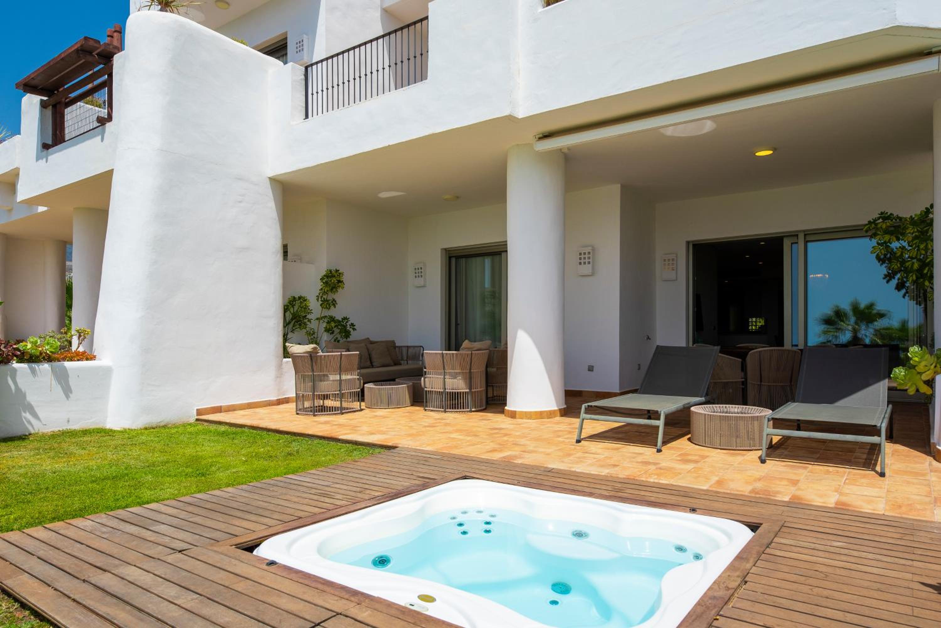 Suite de dos habitaciones con jacuzzi y vista parcial al mar.