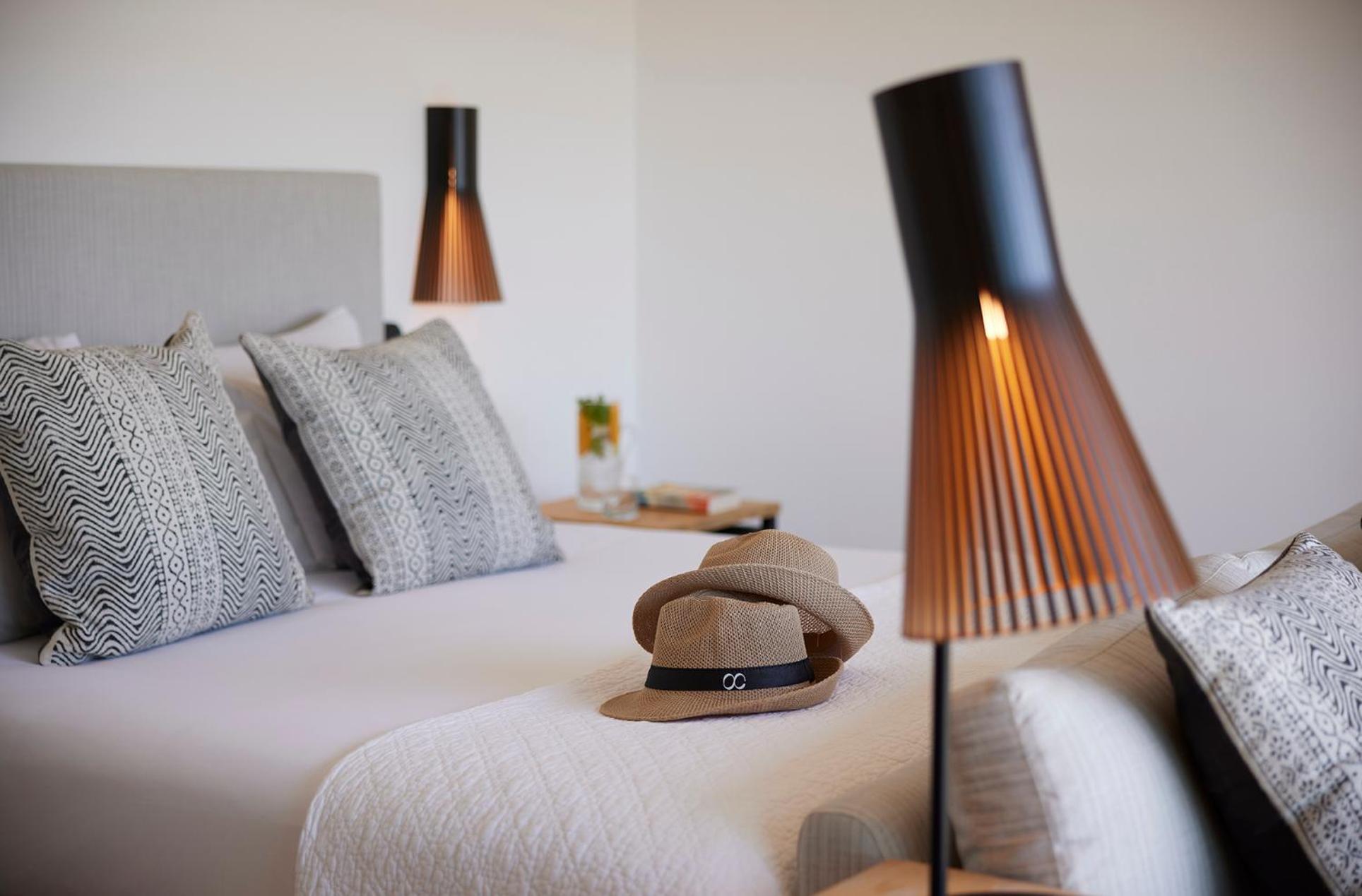 photo of a bed with a hat on top of it