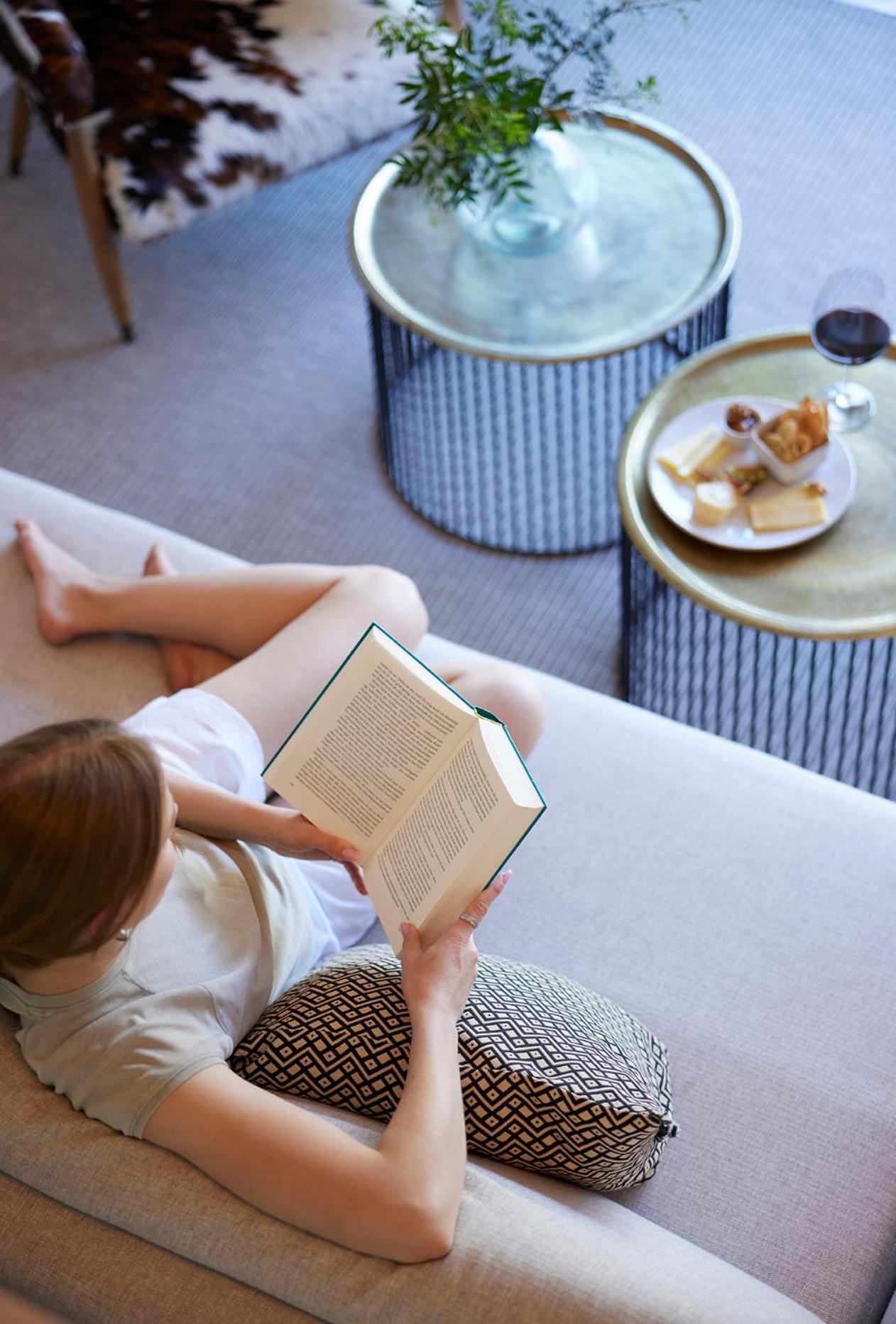 woman sitting on a couch and reading a book?