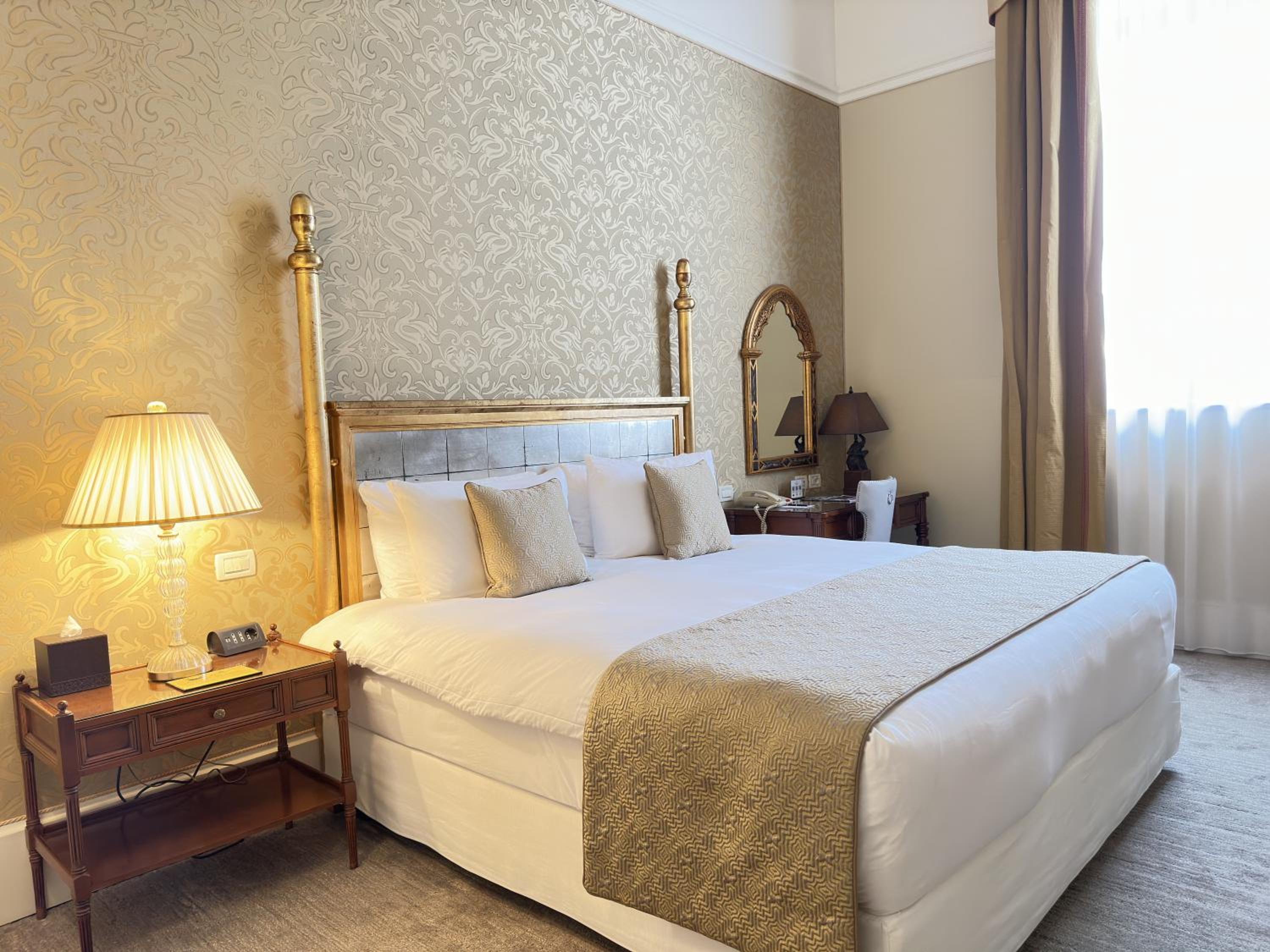 hotel room with a king size bed and gold accents