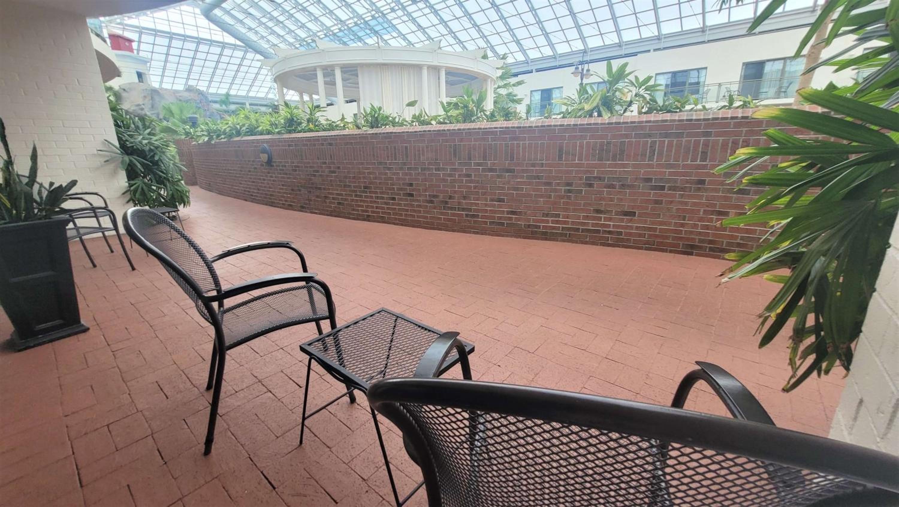 view of a patio with chairs and potted plants