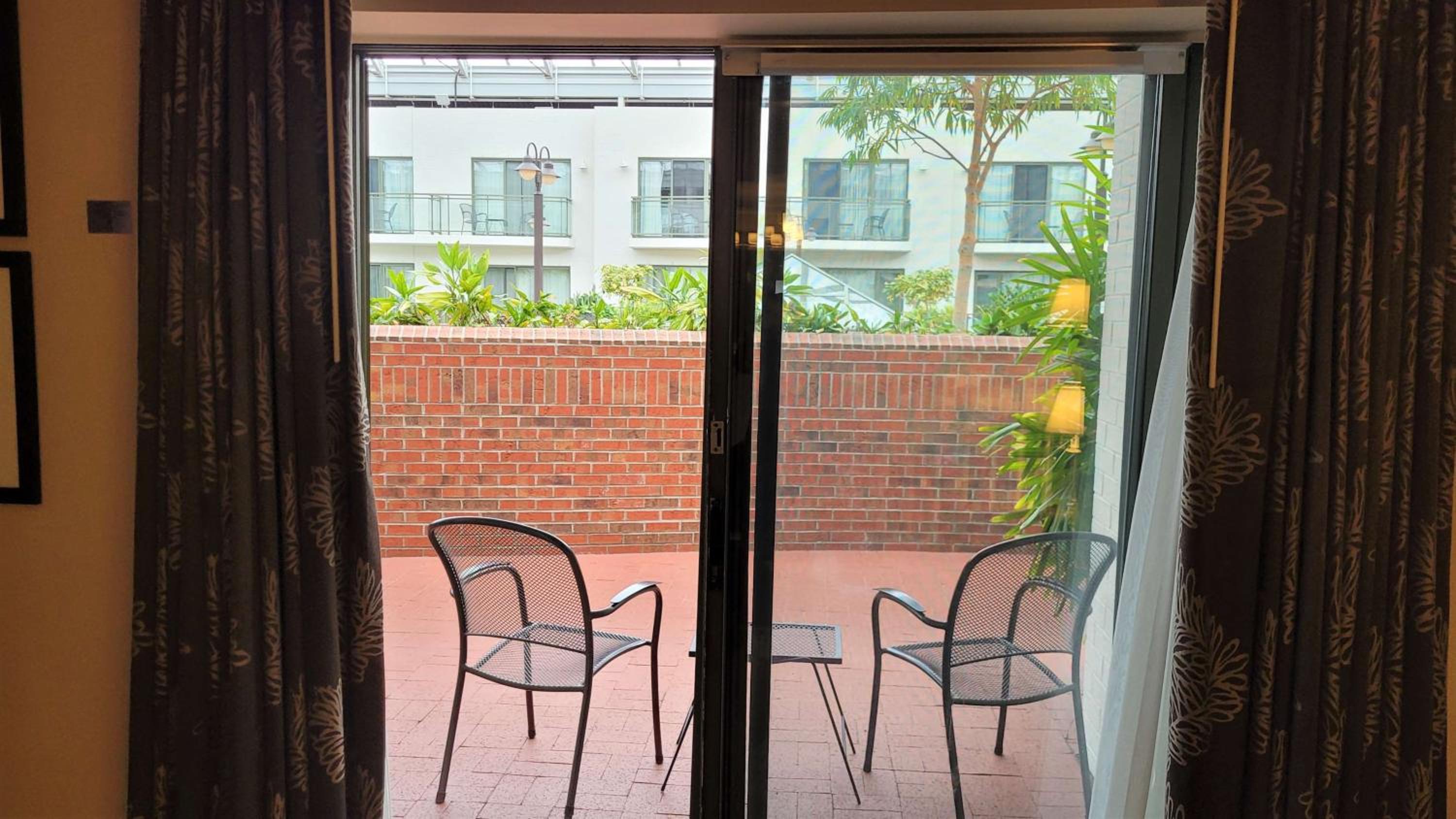 patio with two chairs and a table in front of the sliding glass door