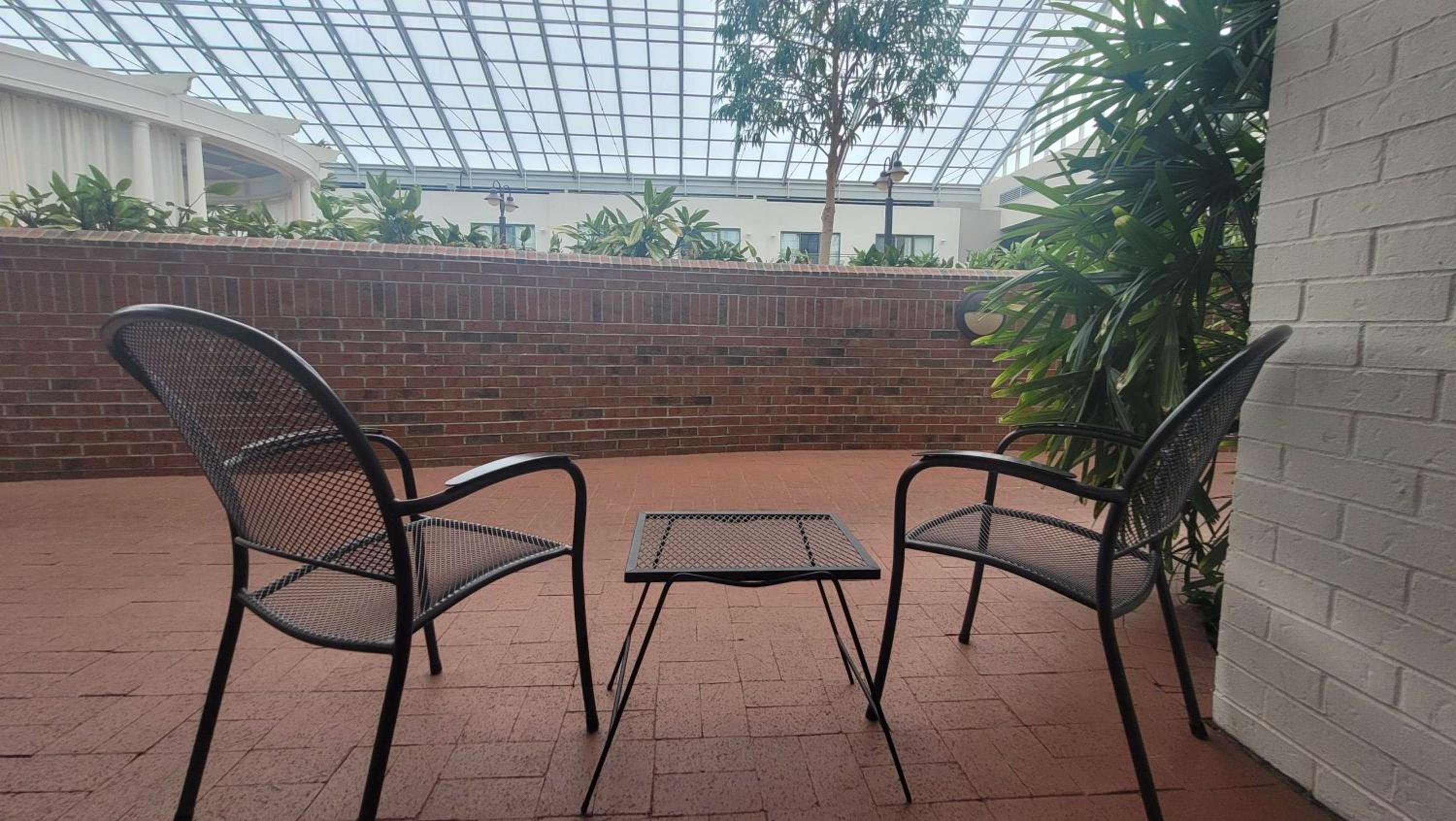 patio with two chairs, a table and a potted plant