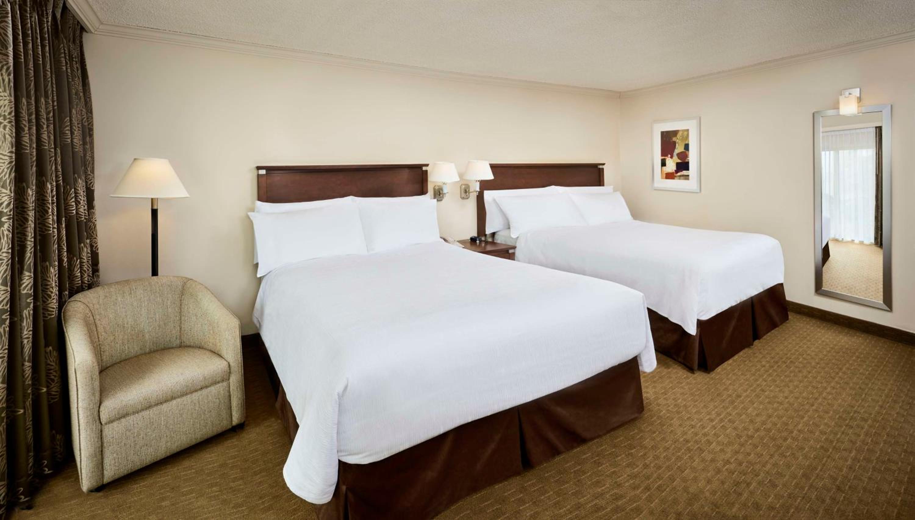 hotel room with two beds and a chair in it