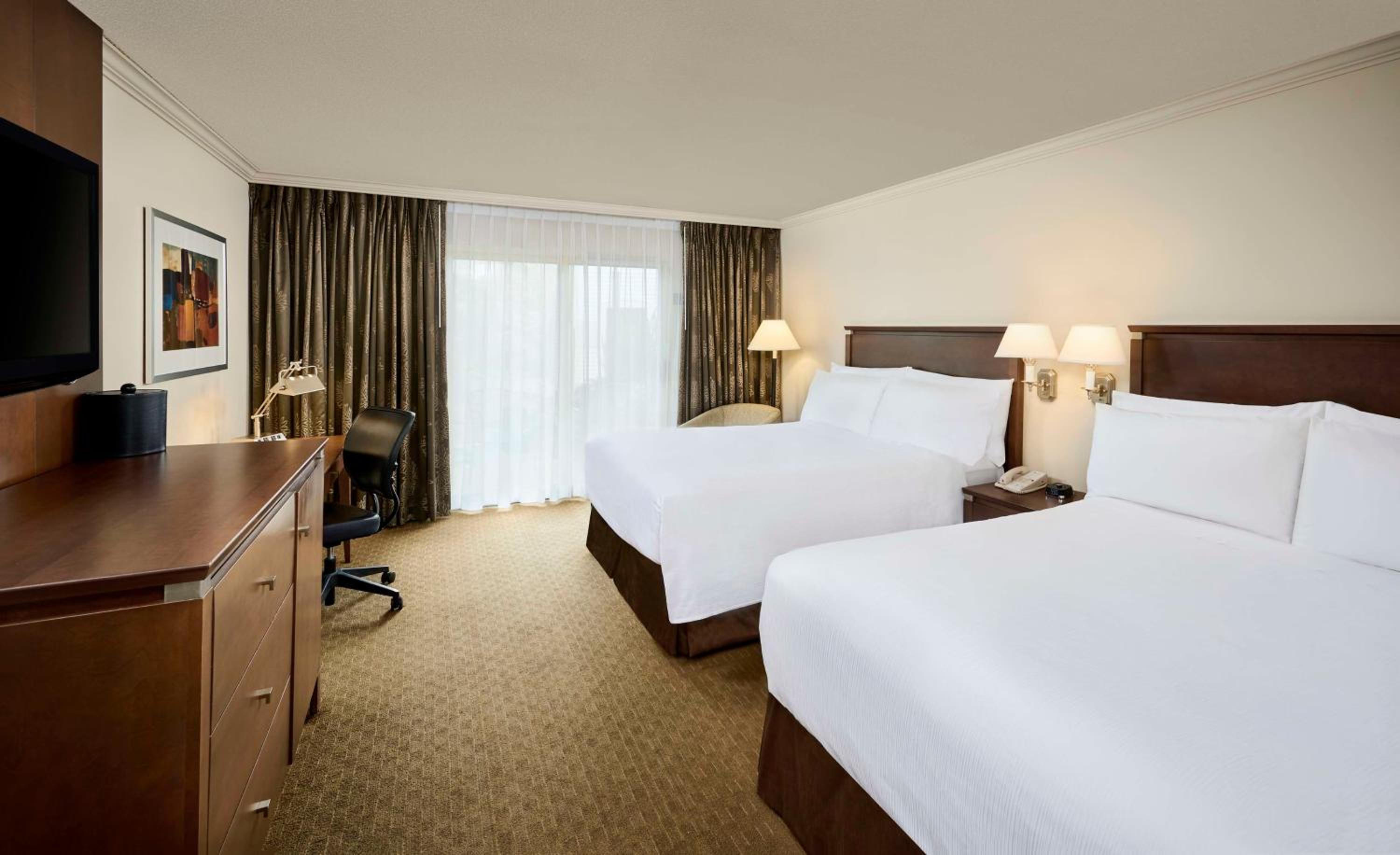 hotel room with two beds and a flat screen tv