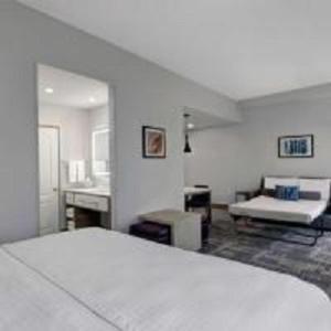 bedroom with a white bed and a gray carpeted floor