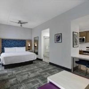 hotel room with a bed, desk, and tv