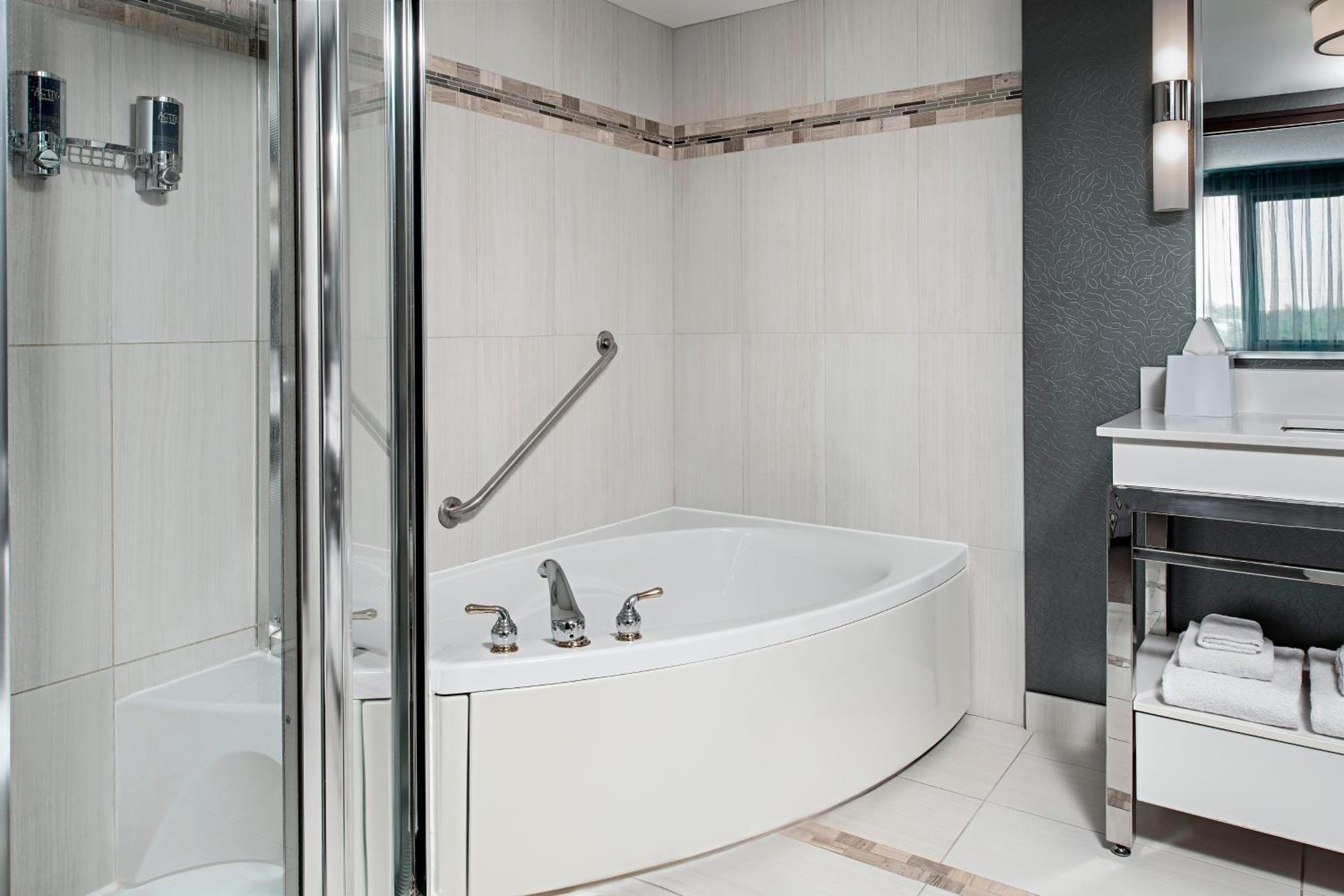 bathroom with a bathtub, sink, and mirror