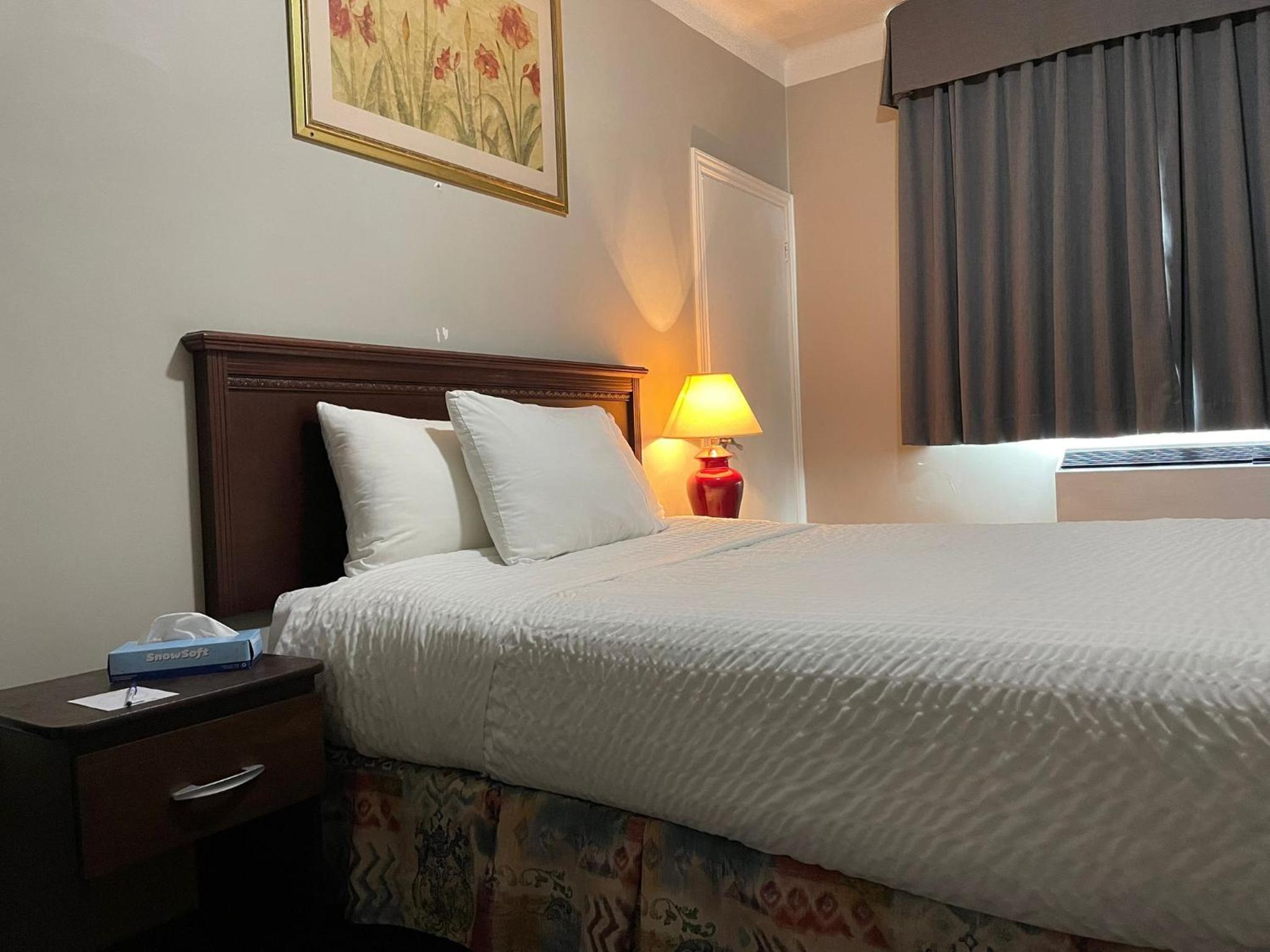 hotel room with a bed, nightstand, and window