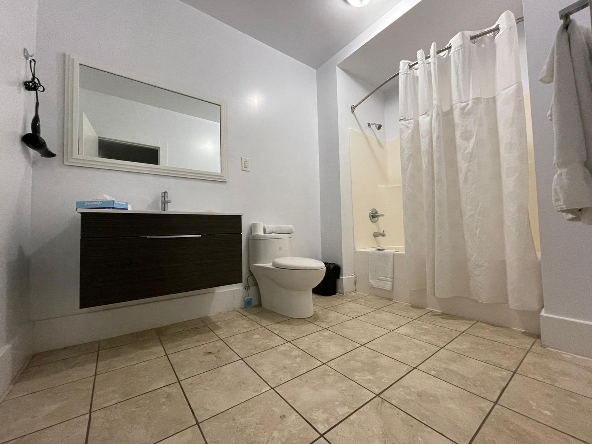 bathroom with a toilet, sink, and shower curtain