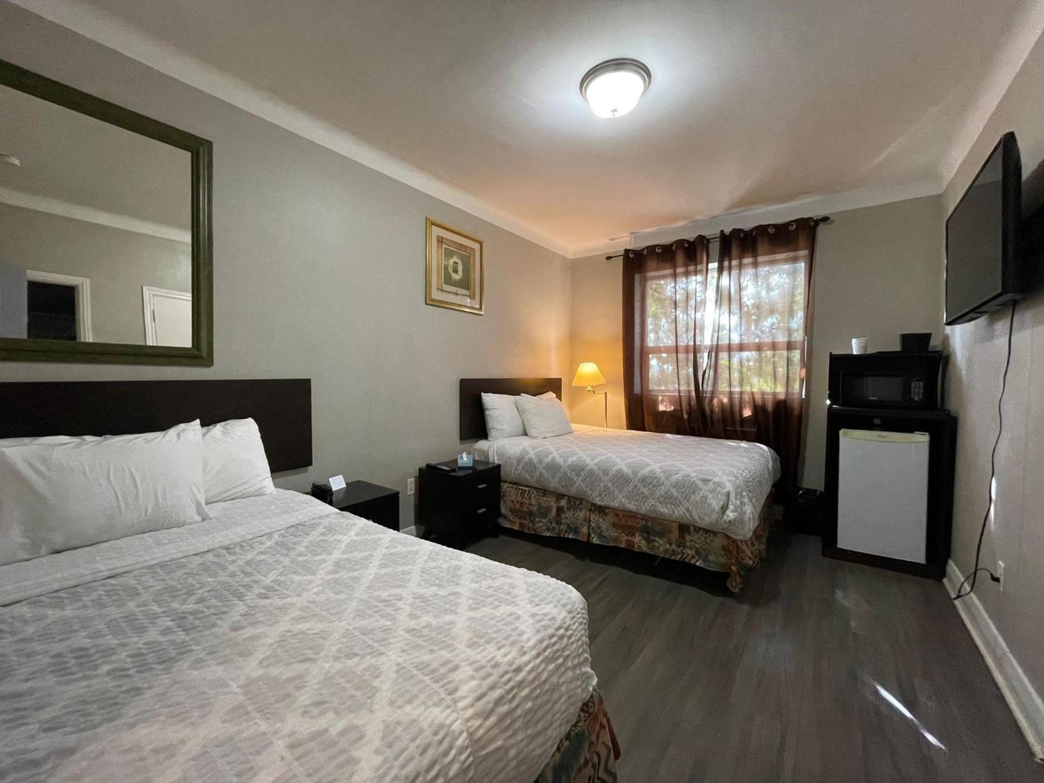 hotel room with two beds and a flat screen tv