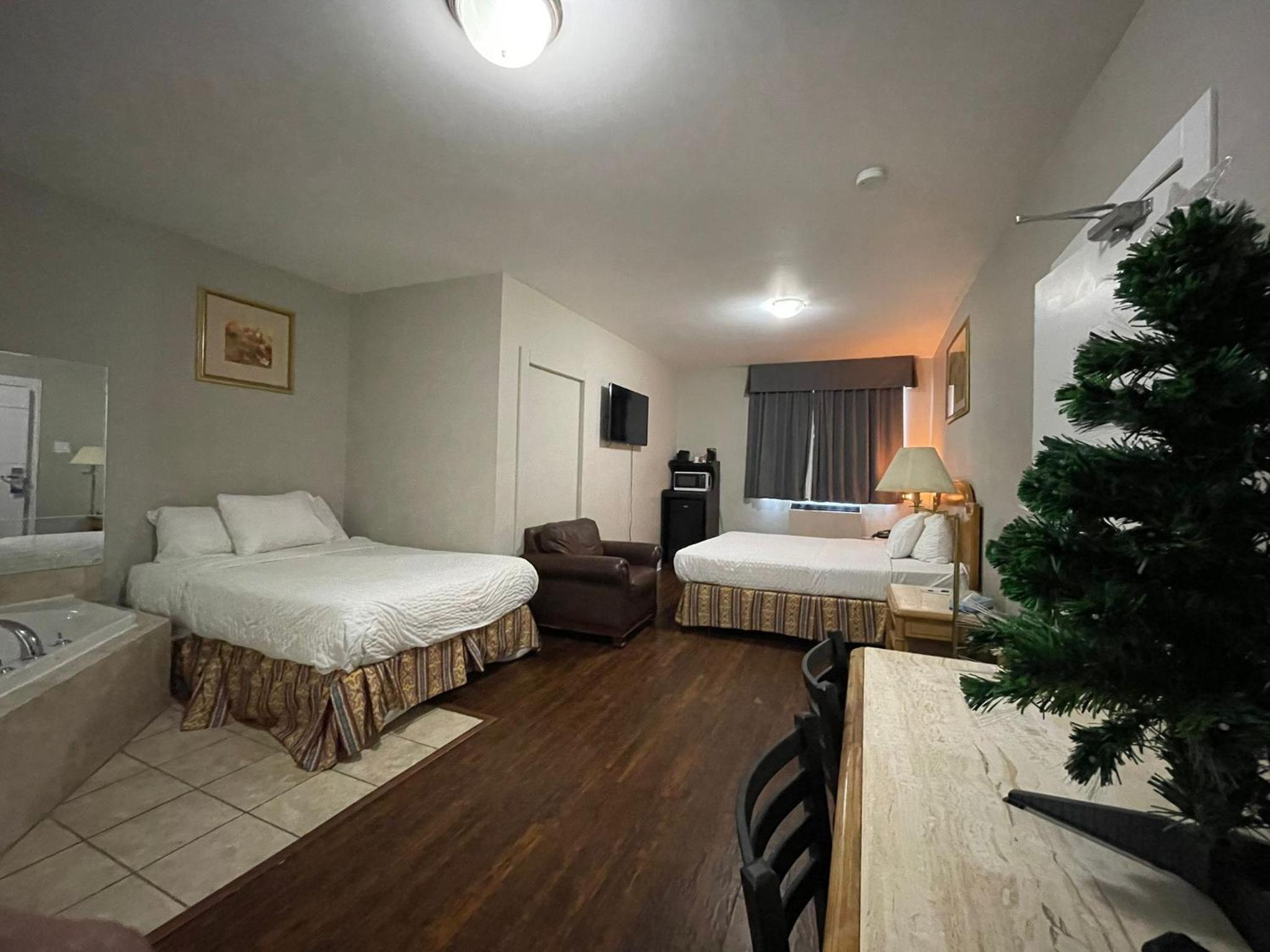 hotel room with two beds and a jacuzzi tub