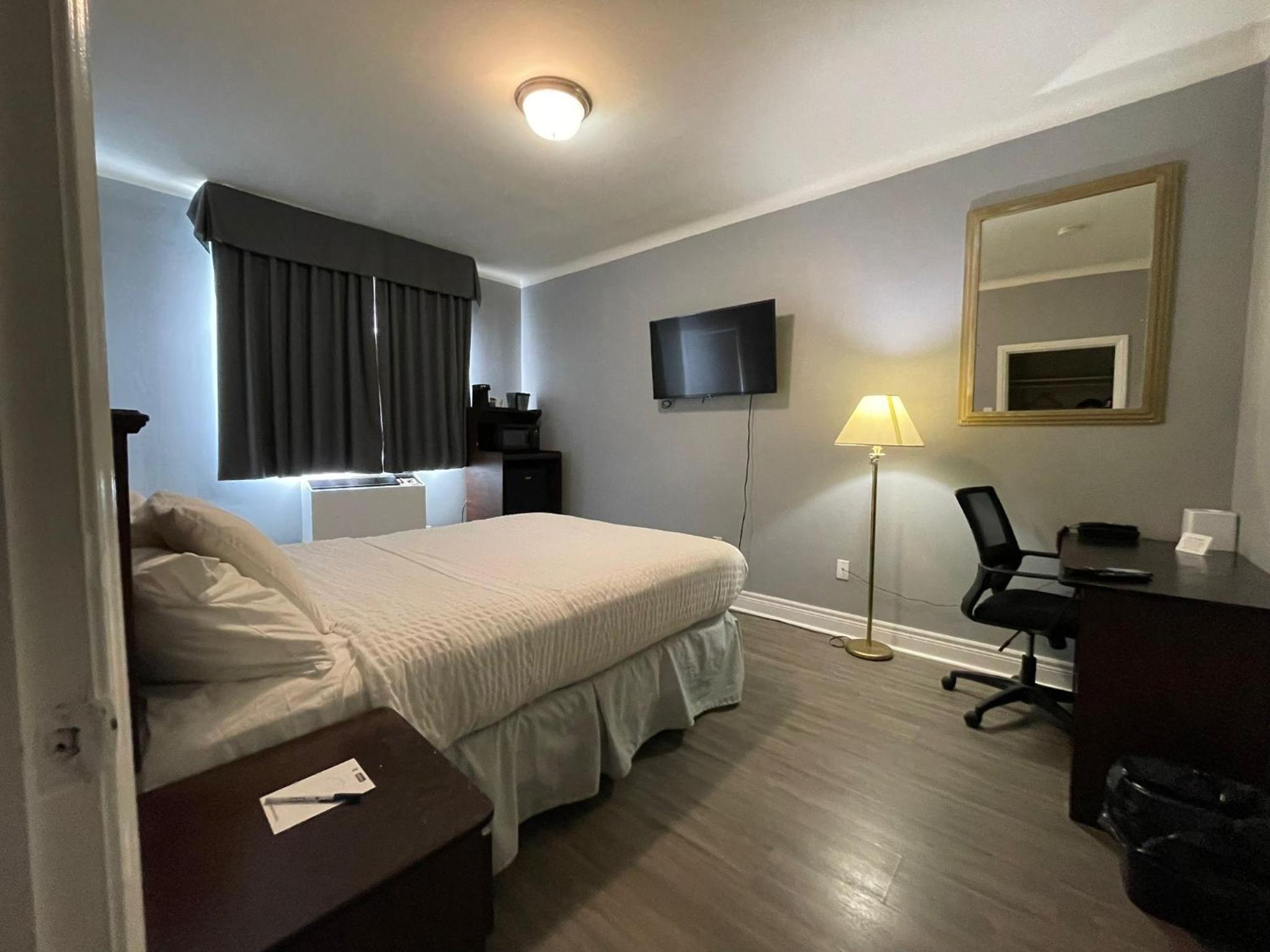 hotel room with a bed, desk, and television