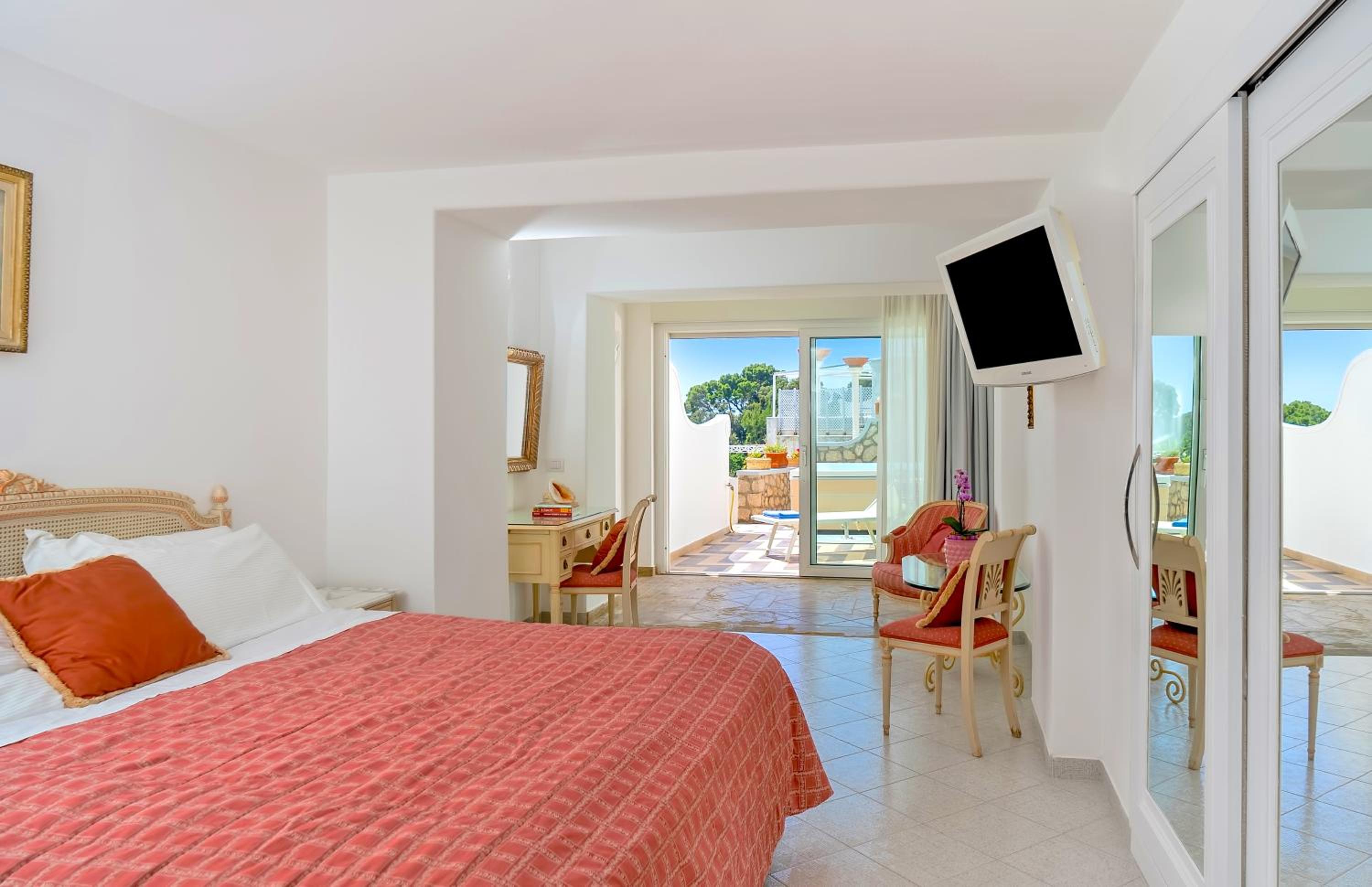 Habitación Doble Deluxe con vista parcial al mar y terraza con jacuzzi exterior.