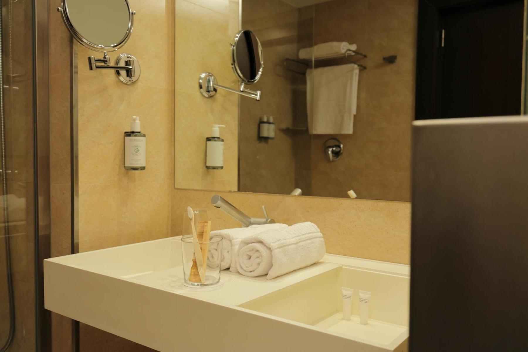 bathroom sink with two towels and a glass of water