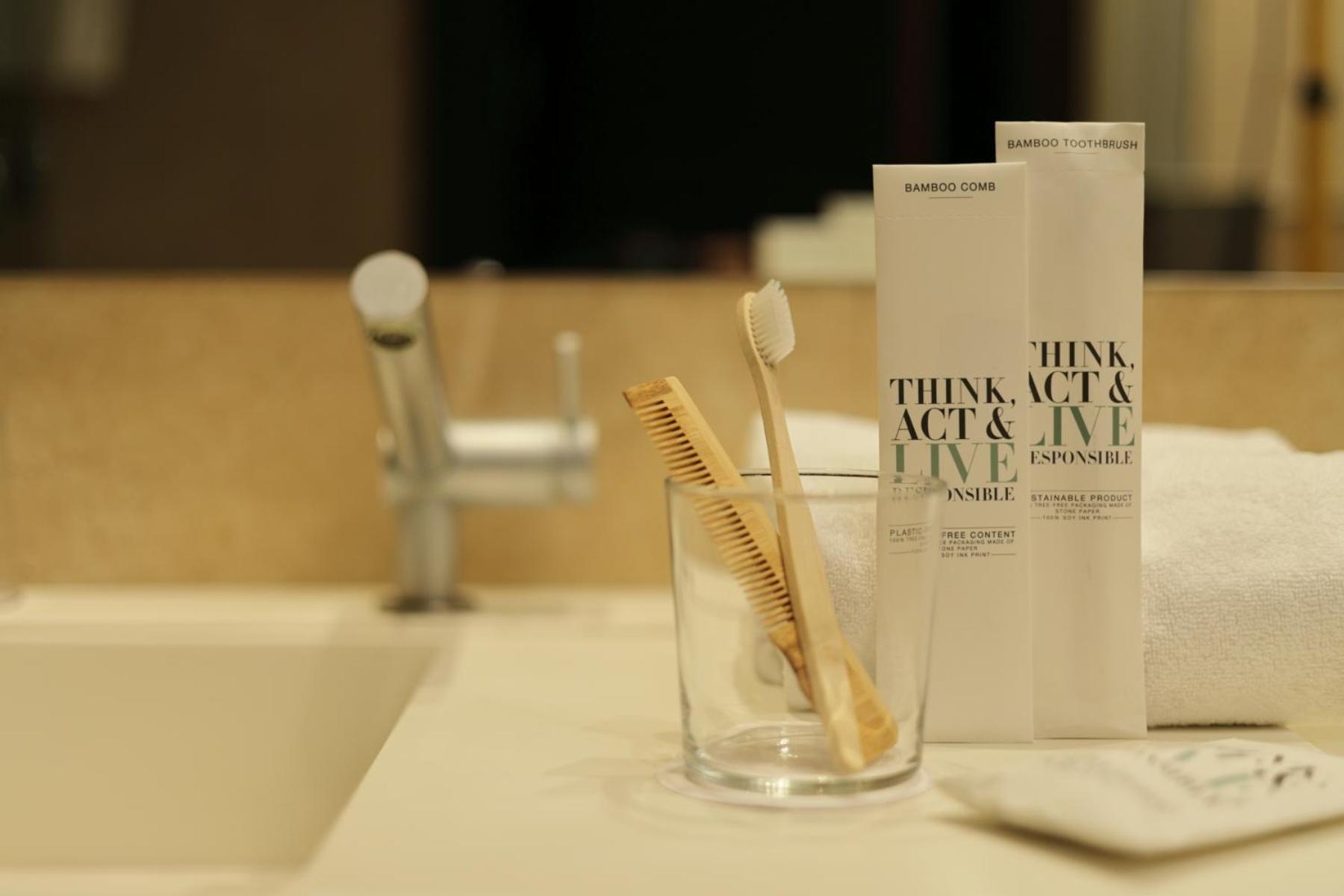 glass of toothbrushes and a book on the counter