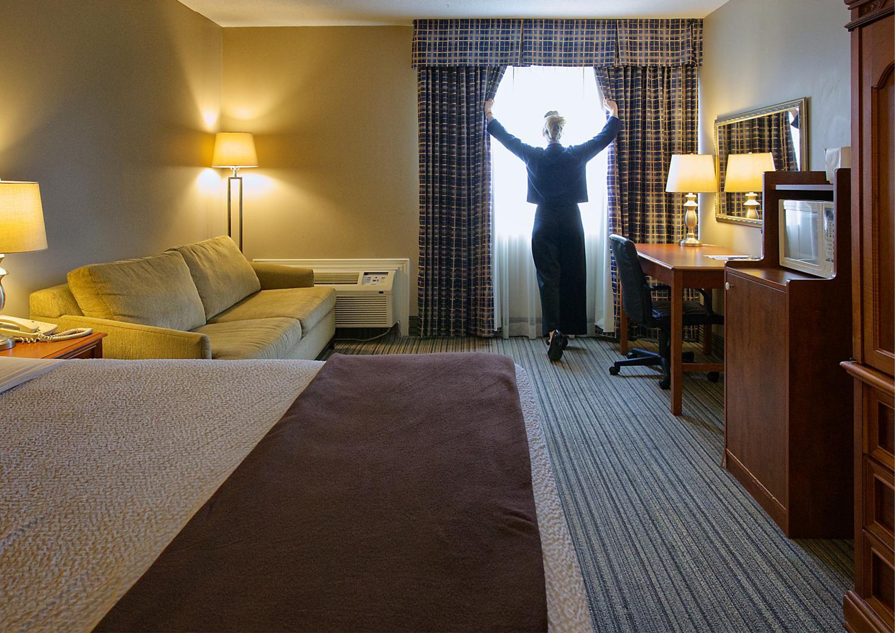 hotel room with a woman standing in front of the window