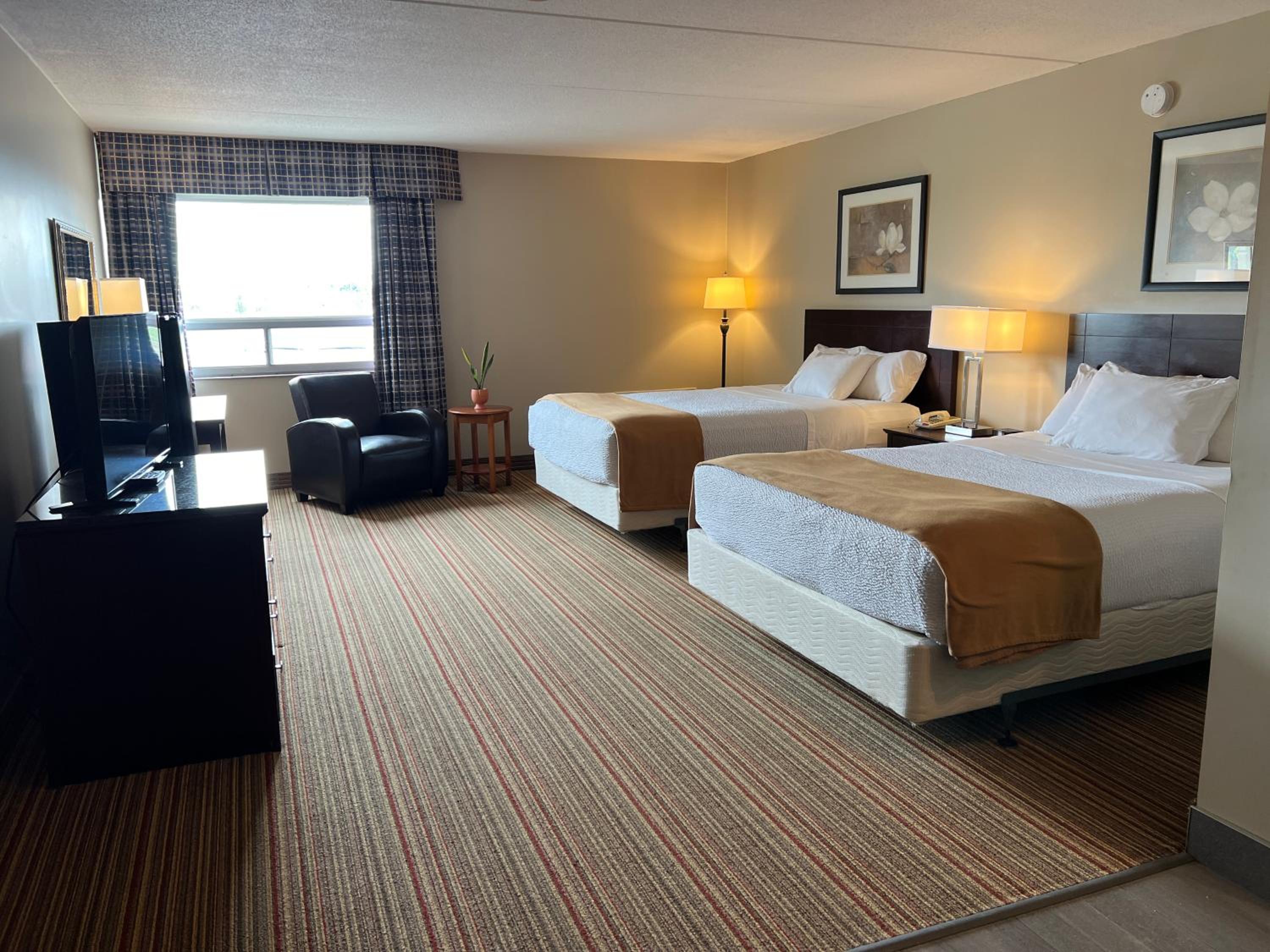 hotel room with two beds and a flat screen tv