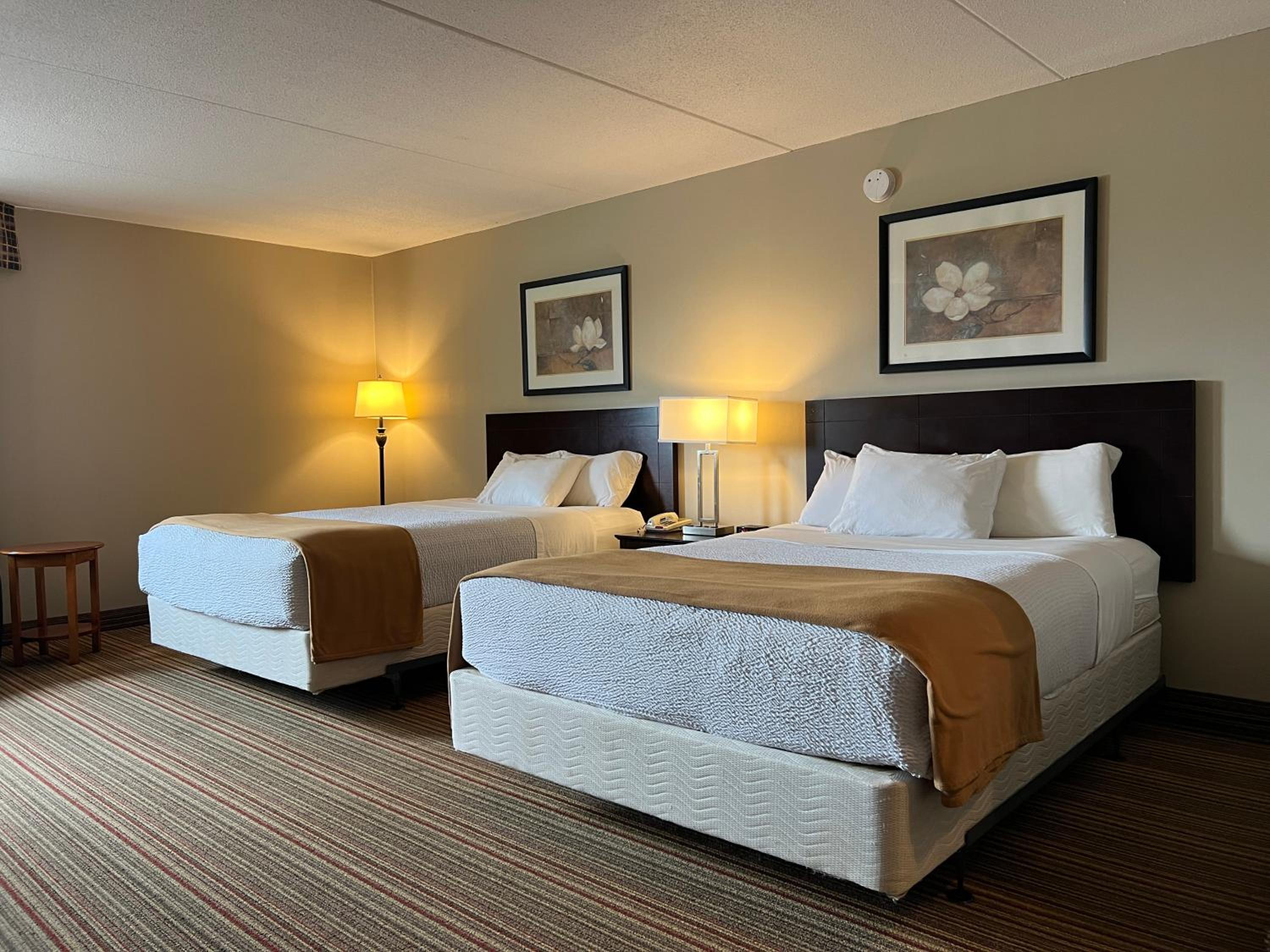 hotel room with two beds and a desk in the corner