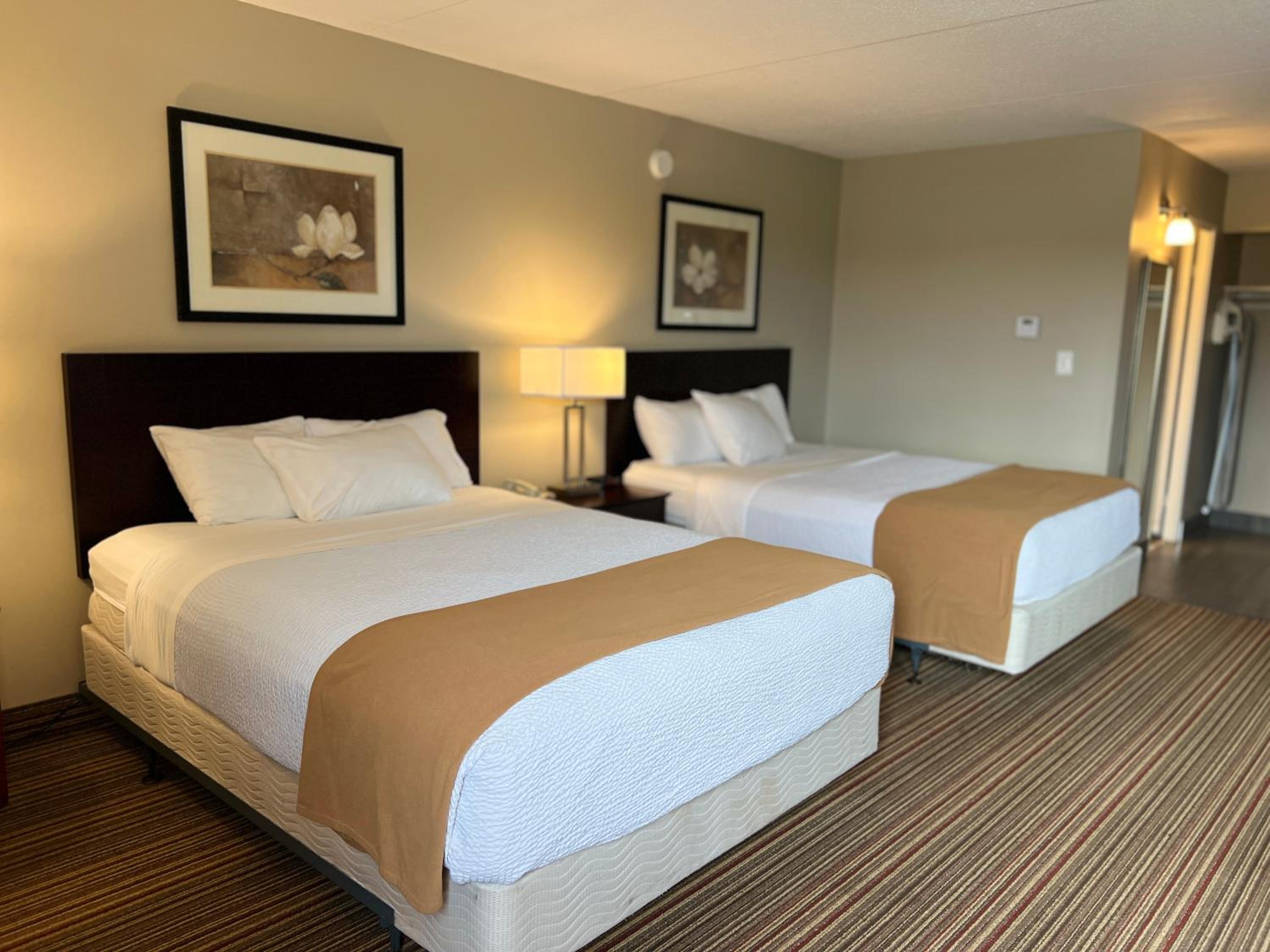 hotel room with two queen sized beds and a flat screen tv