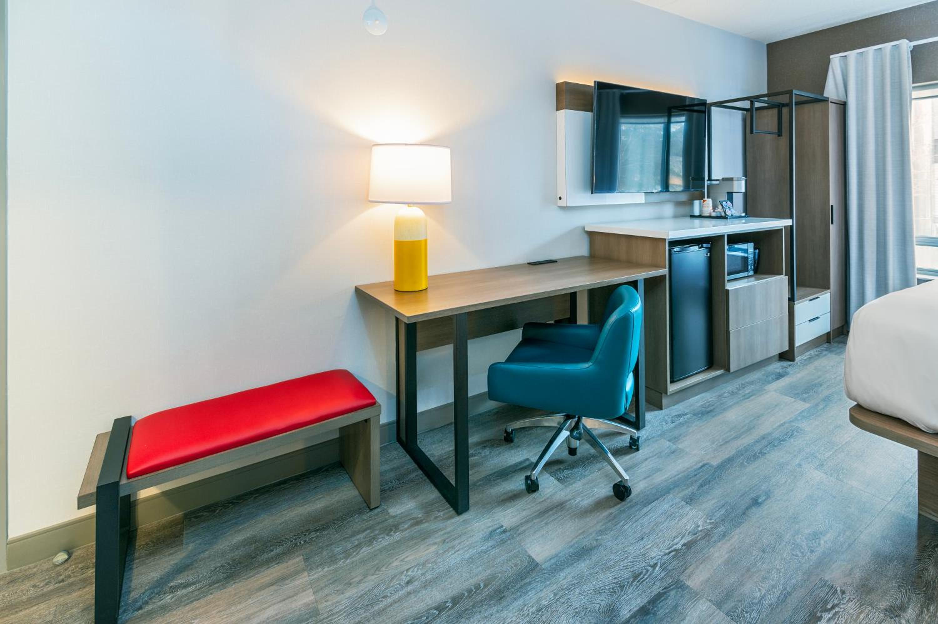 hotel room with a bed, desk, and television