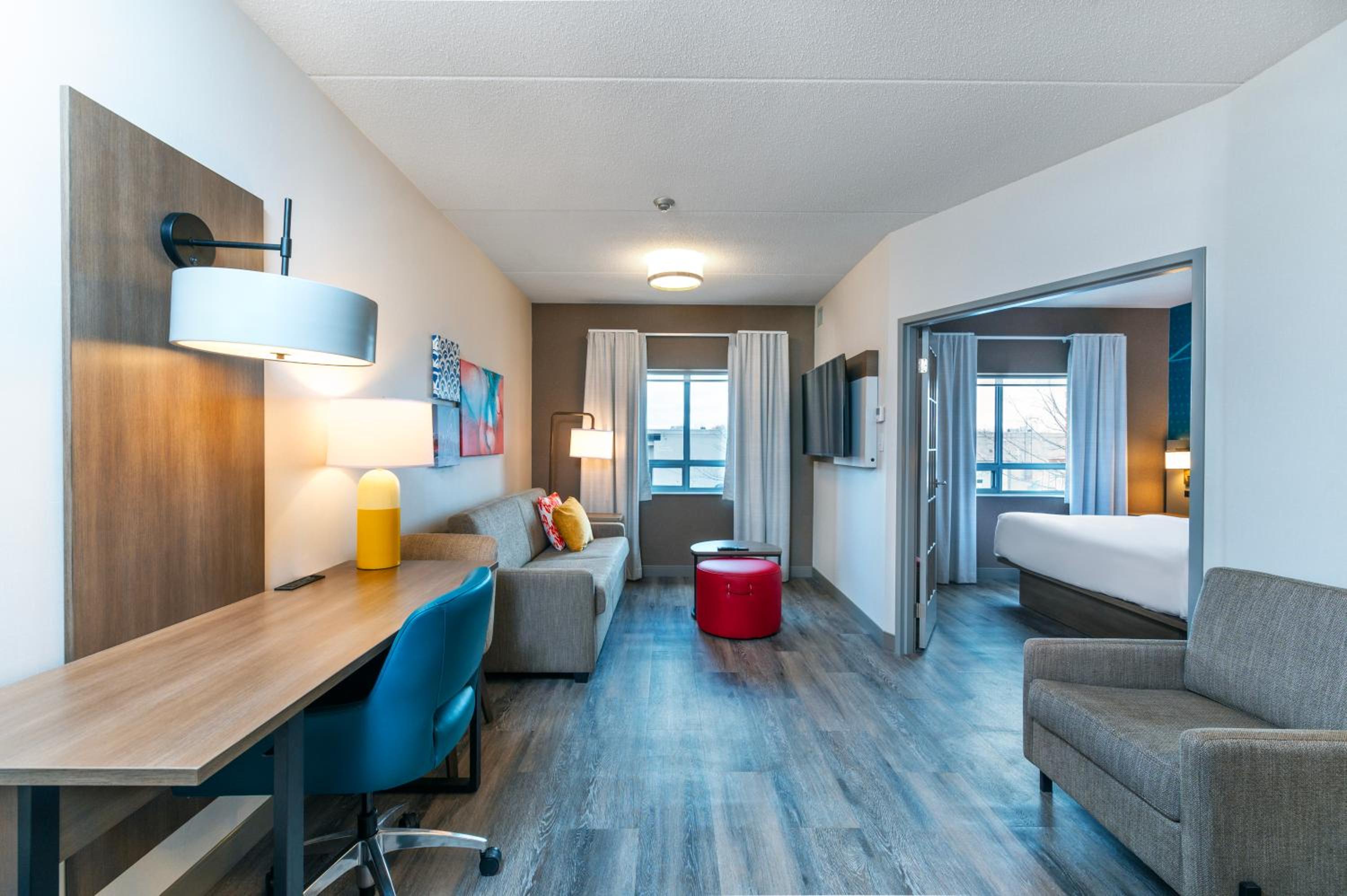 hotel room with a couch, desk, and chair