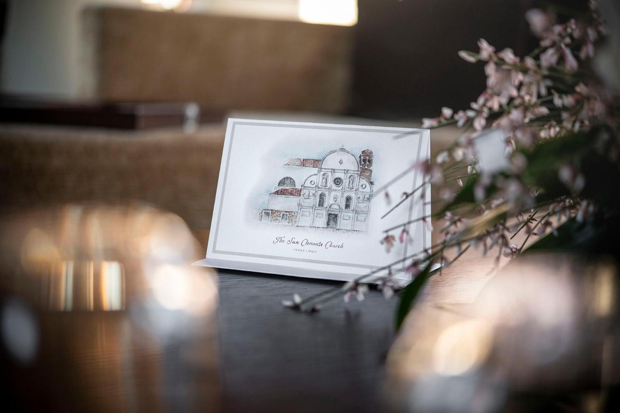 drawing of a church on a table next to some candles
