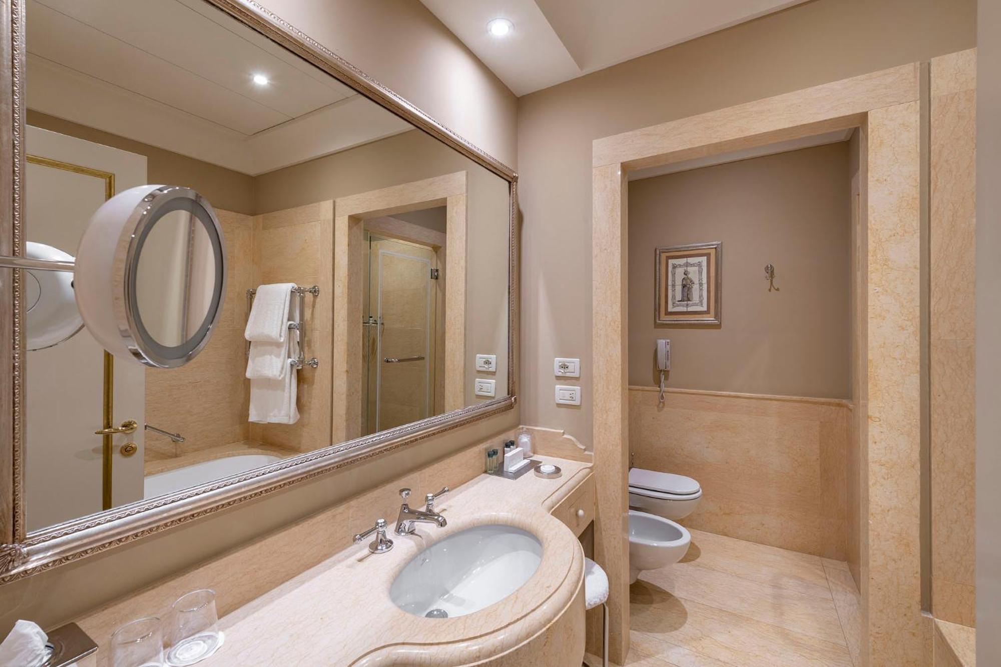 bathroom with a sink, toilet, and large mirror