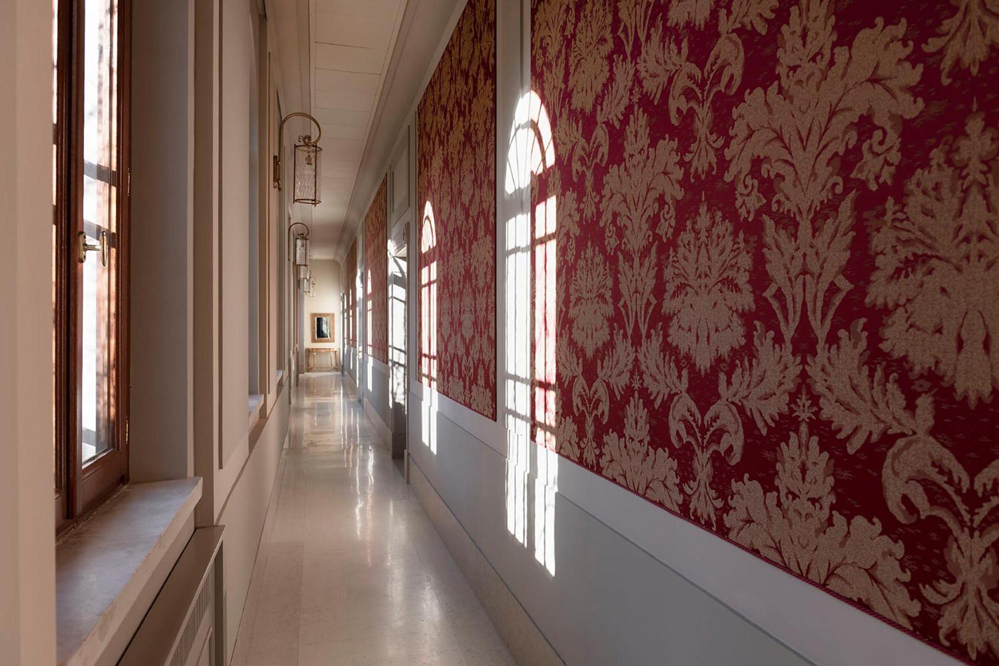 long hallway with red and white wallpapered walls