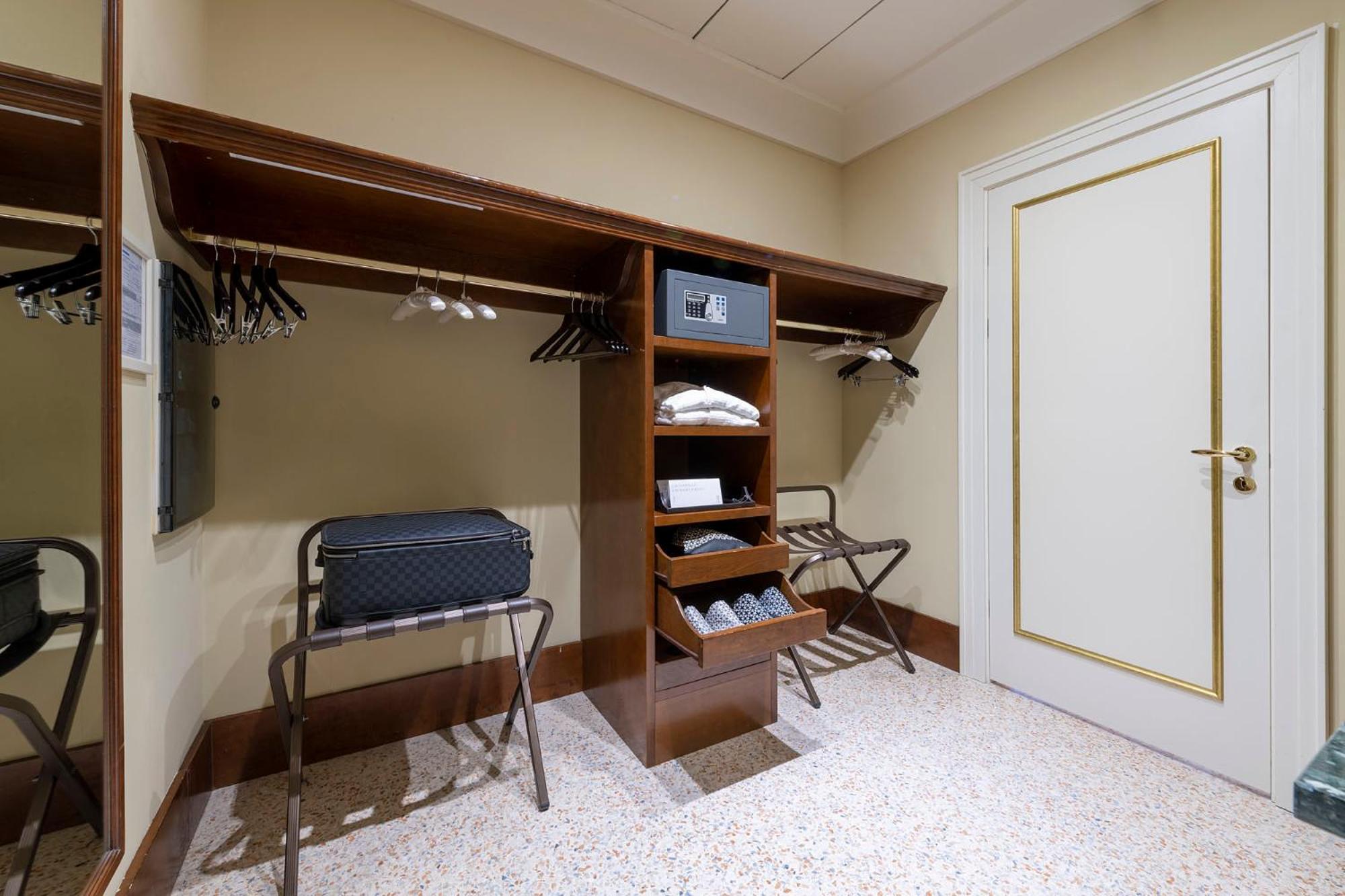 walk - in closet with an ironing board and clothes rack